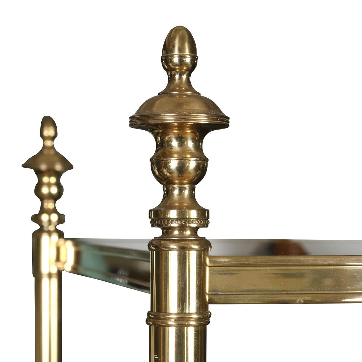 Elegante e versatile, questa étagère a quattro livelli in stile Regency è un'aggiunta straordinaria a qualsiasi interno. Caratterizzata da una struttura in ottone lucido con dettagli classici e ripiani neri, offre un mix perfetto di raffinatezza