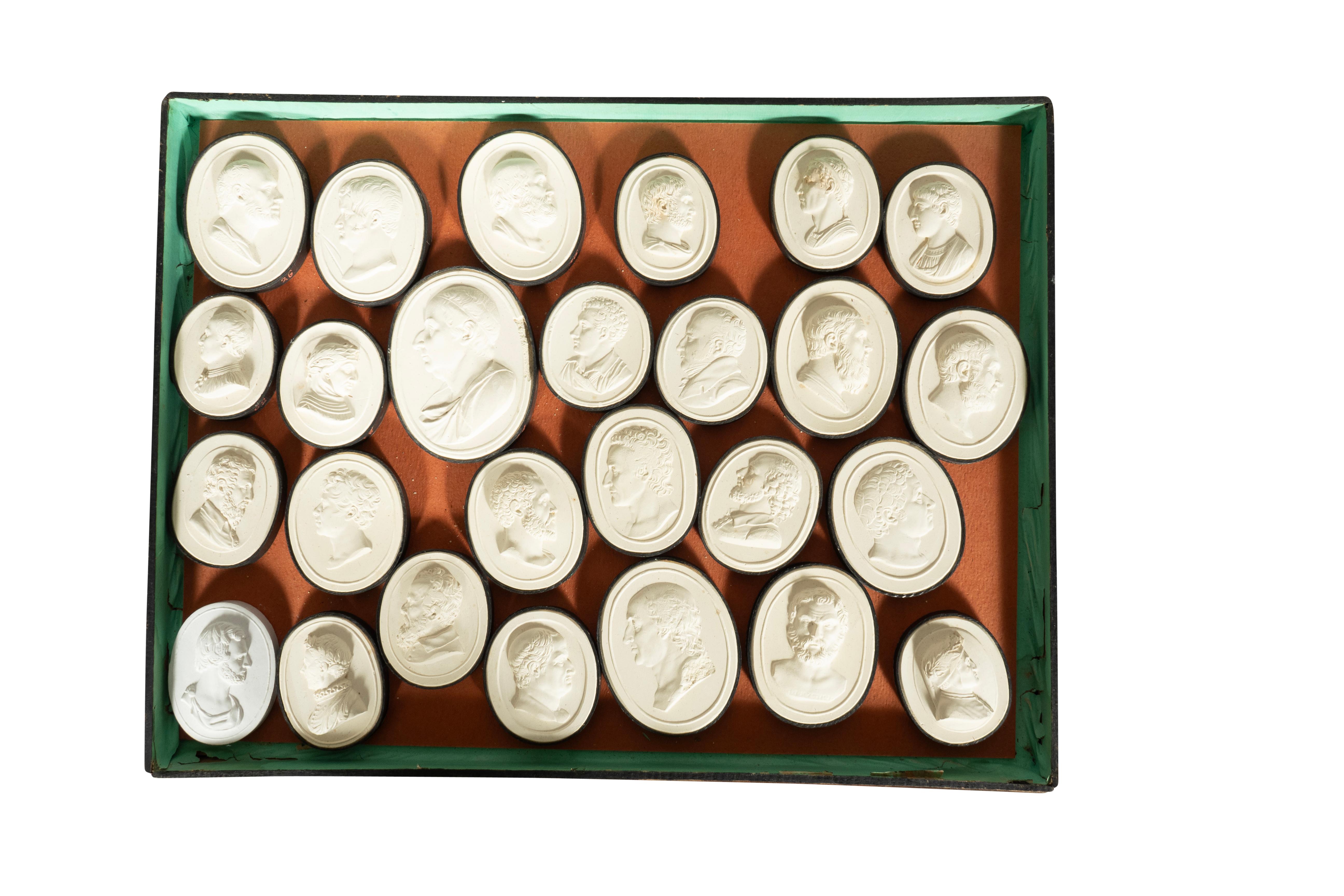 Four trays each holding loose portrait intaglios. The trays stack to form a box. On reverse of top hand written list of ancient Roman rulers. Intaglios in very good condition and box is in fair condition.