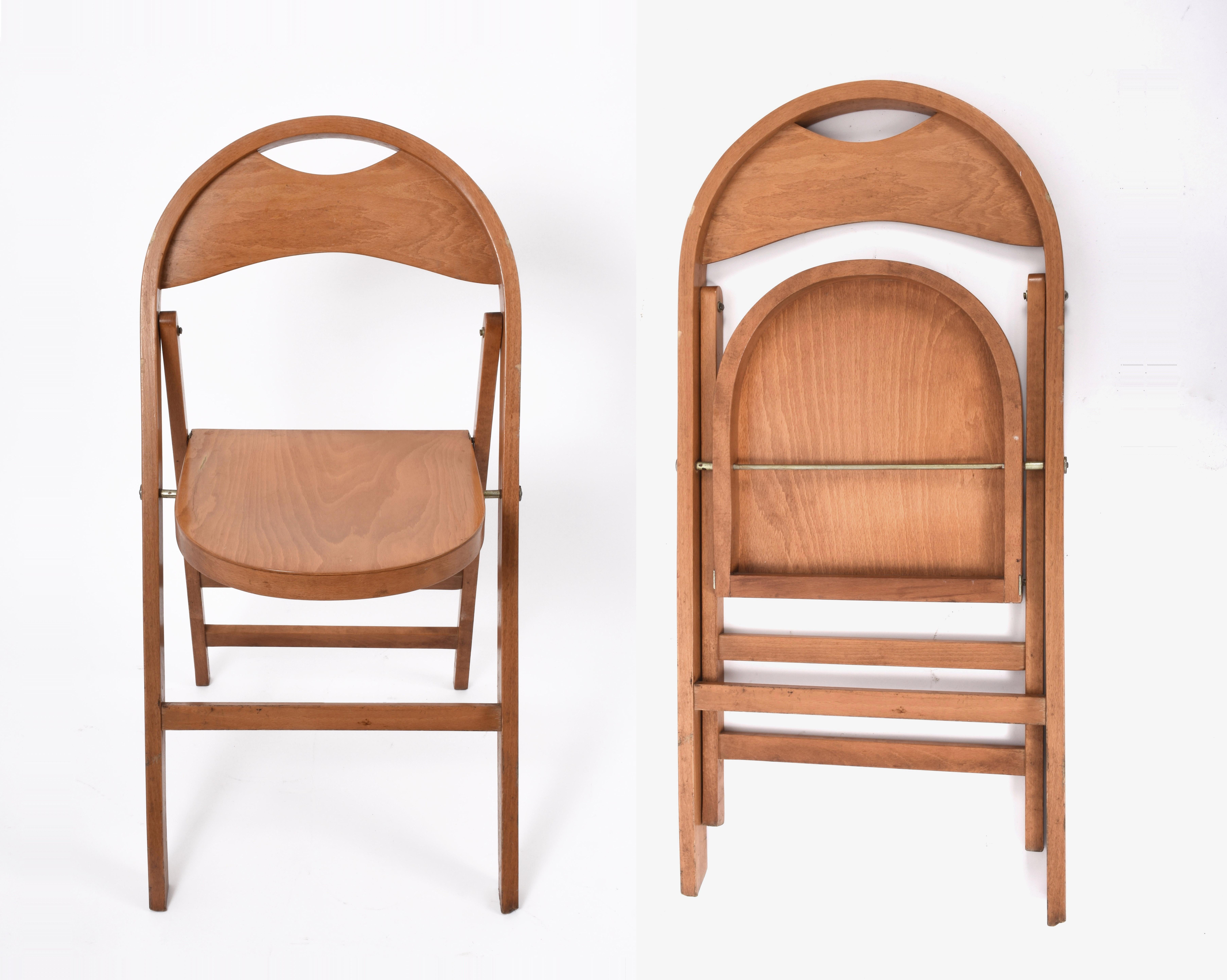 Four solid wood folding chairs.

The design is inspired by the round shapes of the 1930s. Its creation was made possible thanks to the collaboration of BBB in 1965, a company characterized by innovation and research. The chair is very practical