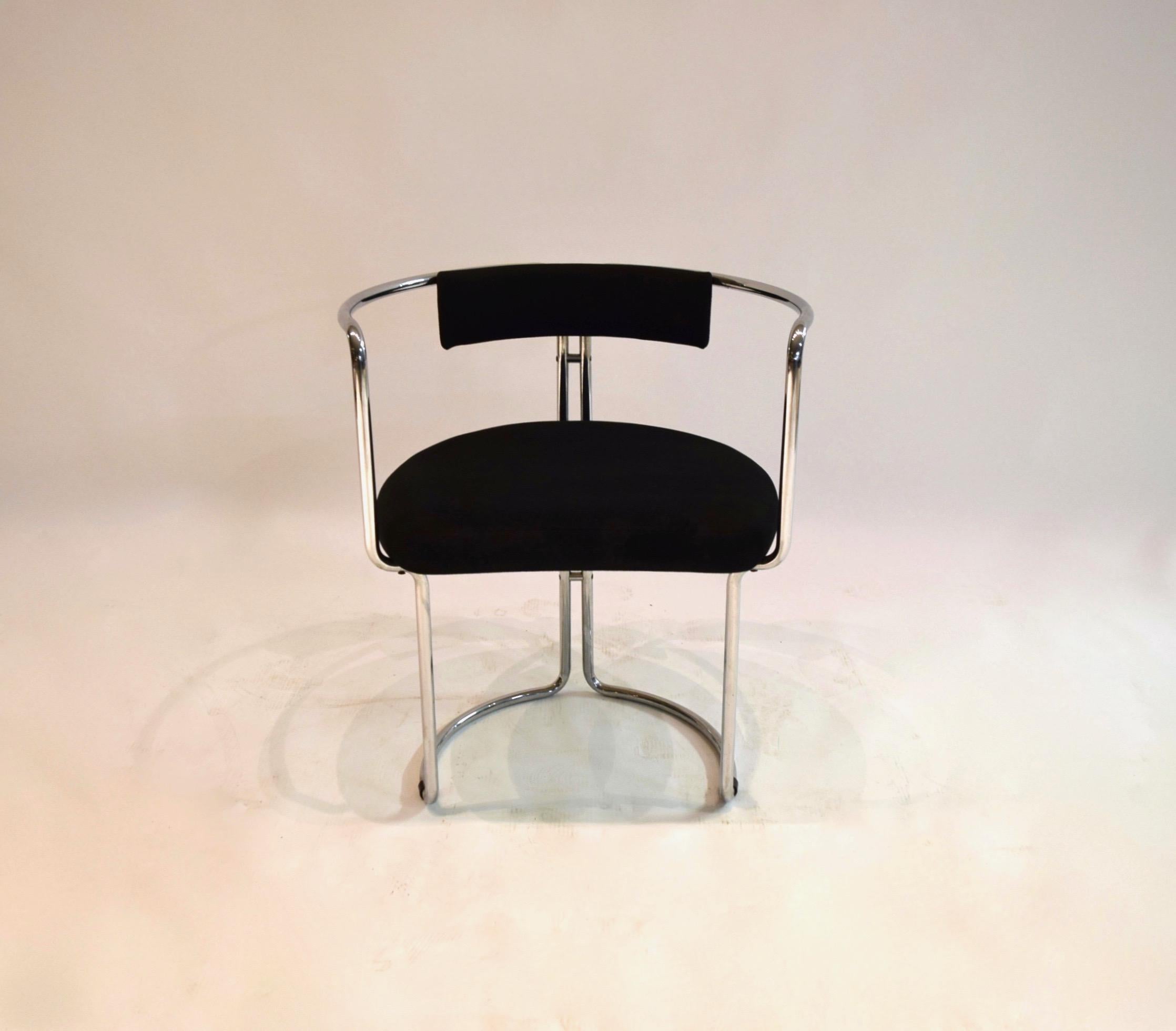 Four tubular chrome-plated metal framed chairs with curved corners, a U-shaped at the base, and a rounded back. The backrest and seat cushion are upholstered in a black ribbed fabric and have the Otto Gerdau and made in Italy labels on the underside