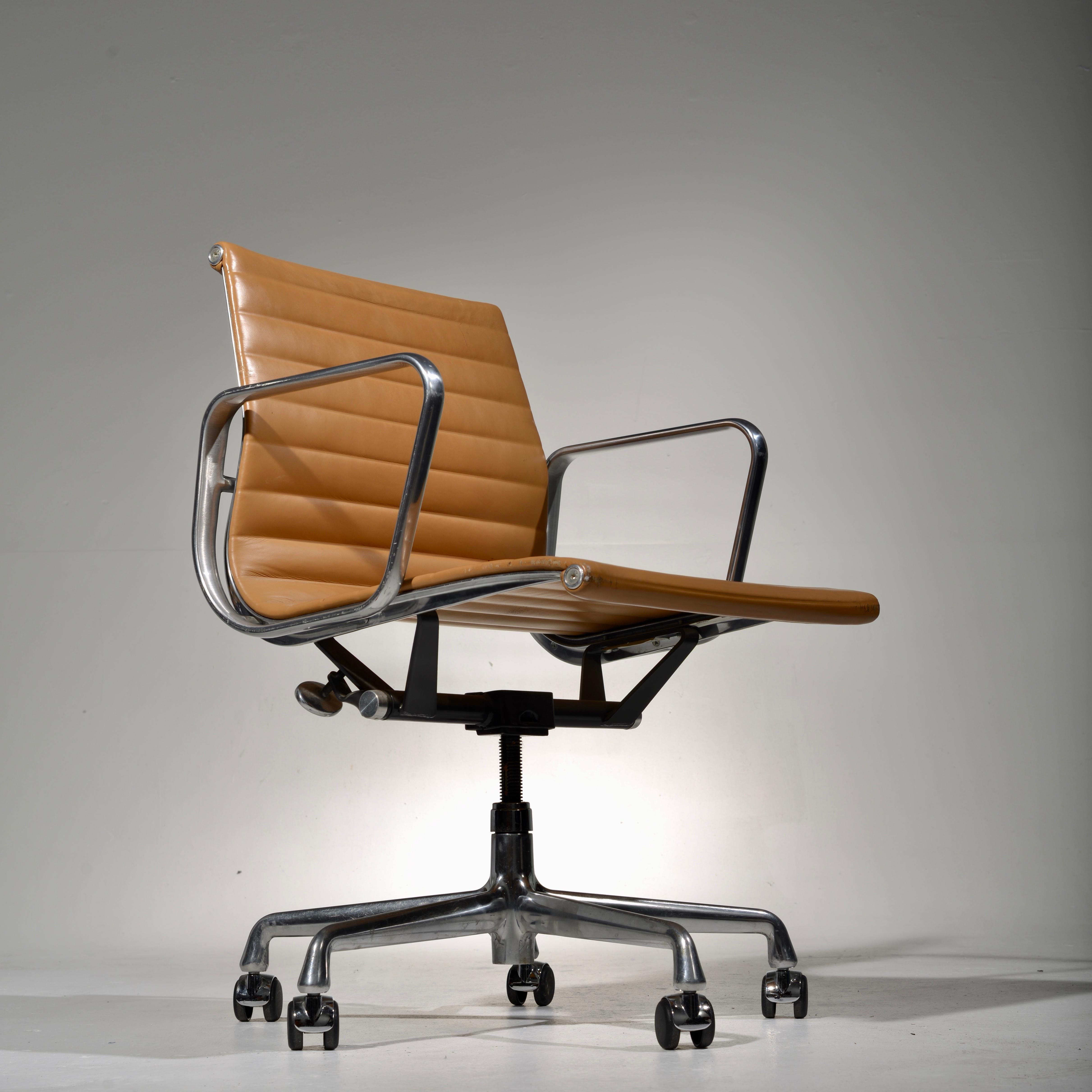 Set of 4 Eames Aluminum Group desk chairs on a five-star, swiveling, rocking, rolling base with matching arms, in a very rare tan leather. Seat height is adjustable. These chairs are in excellent condition. The leather is soft and pliable. Sold