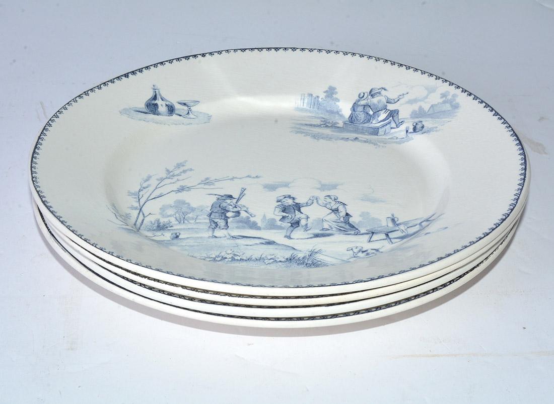 The four charming dinner plates have blue country scenes on cream 