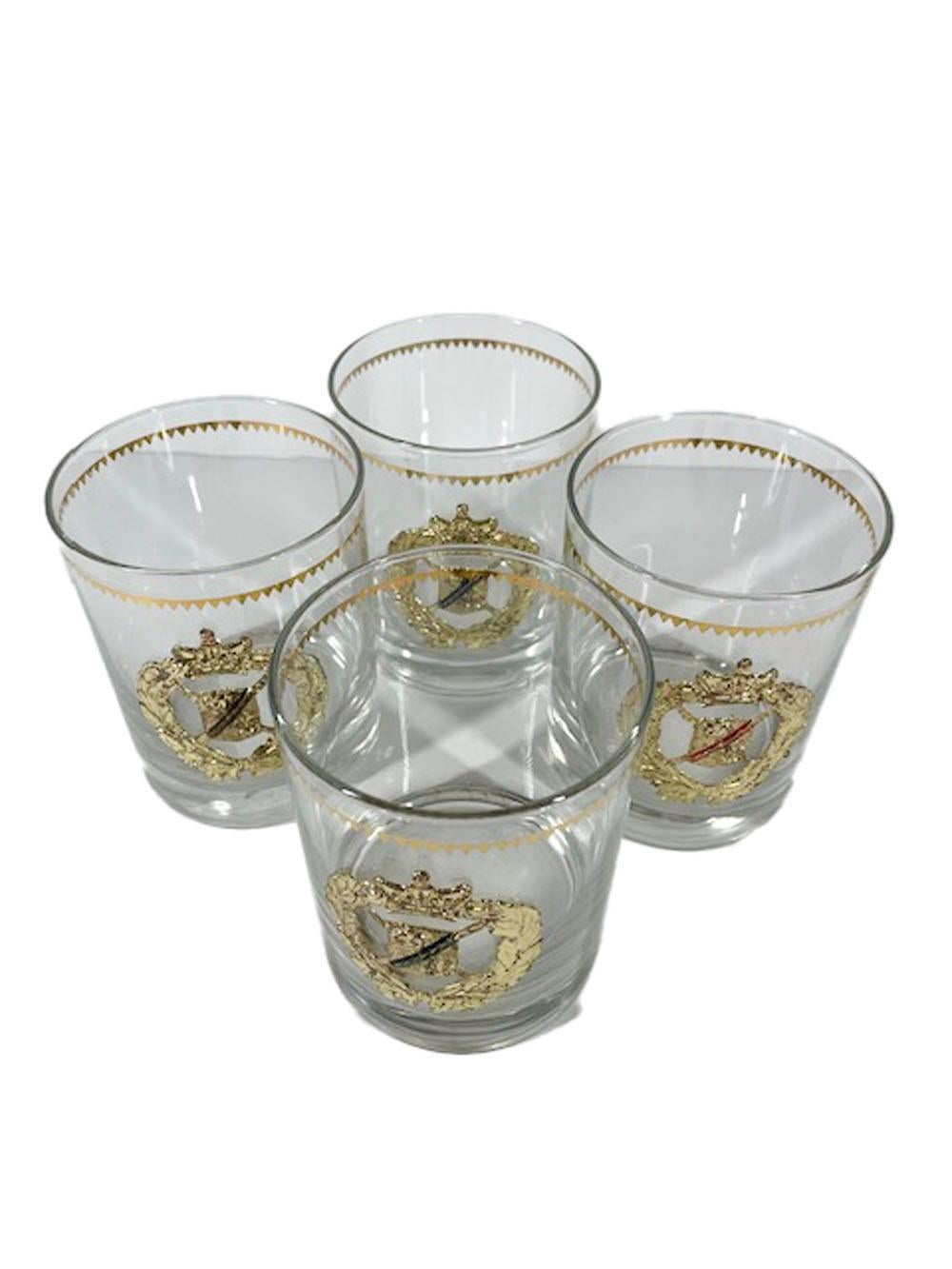 Set of 4 Mid-Century Modern rocks glasses designed by Georges Briard. Each having a saw-toothed gold band above an applied gilt metal laurel wreath centering an heraldic shield, each shield with a different colored enamel diagonal line.