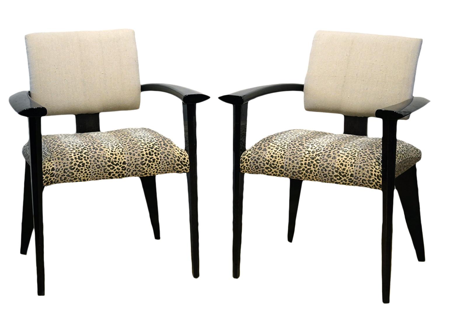 These elegant Italian chairs feature wide air-wing shaped armrests continuing around the back, upholstered seats and backrests resting on modern faceted geometric legs. The framework is lacquered in a way that let the wood grain shine through. The