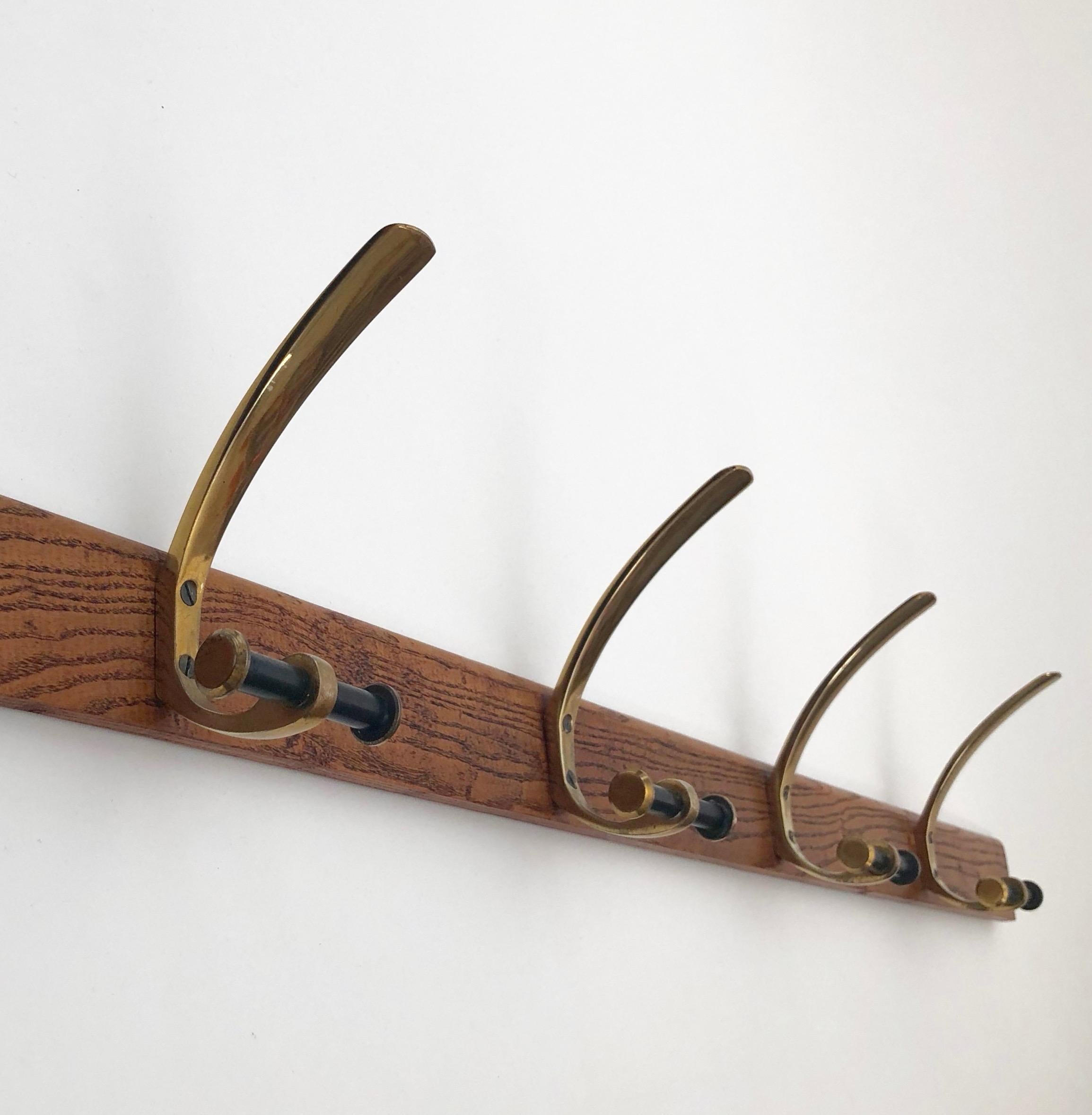Four brass wall hooks from Hetha Baller mounted on a oak wood frame. The frame can be attached to the wall with screws.
The wood has been oiled and finished with wax. To the touch, its baby smooth.