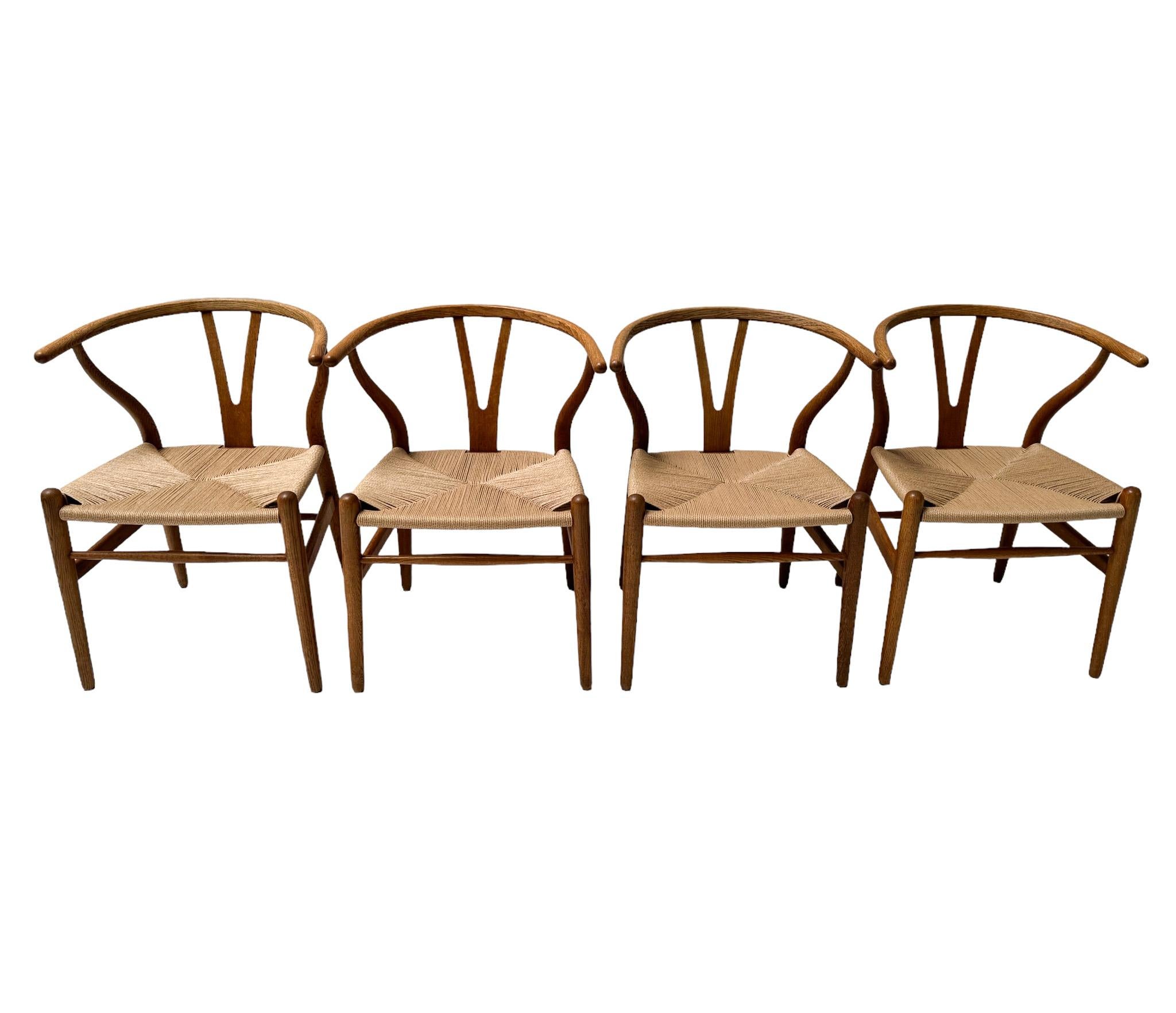 Magnificent and rare set of four Mid-Century Modern Wishbone CH 24 dining room chairs.
Design by Hans J Wegner for Carl Hansen & Søn Denmark.
Striking Danish design from the 1950s.
Solid patinated oak frames with new woven papercord seats.
All four