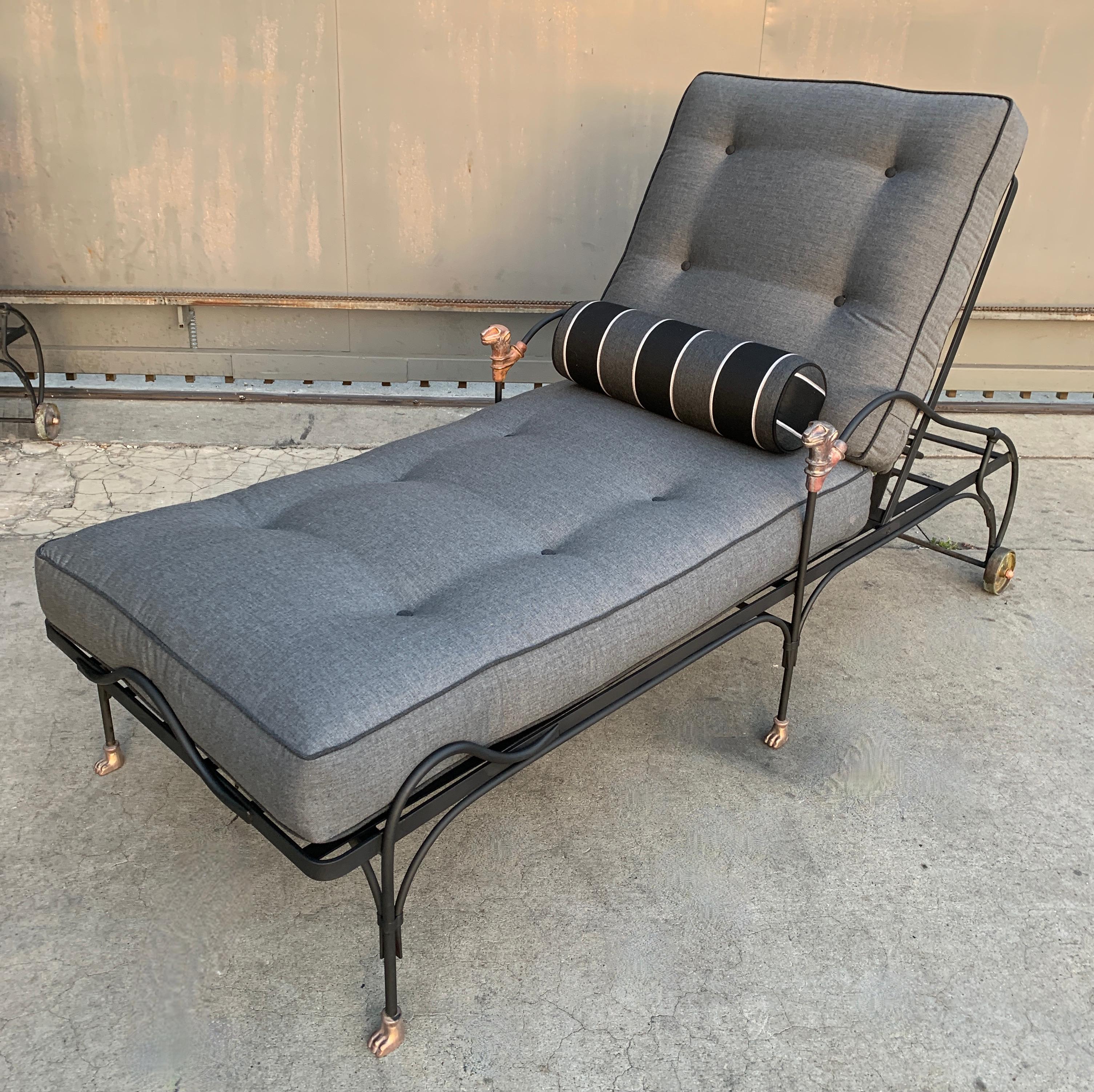 Four phenomenally designed outdoor wrought iron chaise lounges with sculpted head, paw feet and wheels sculpted of statuary bronze. The thoughtful design of the lounges has a curved handle at the base and head of the lounge for ease of movement. The