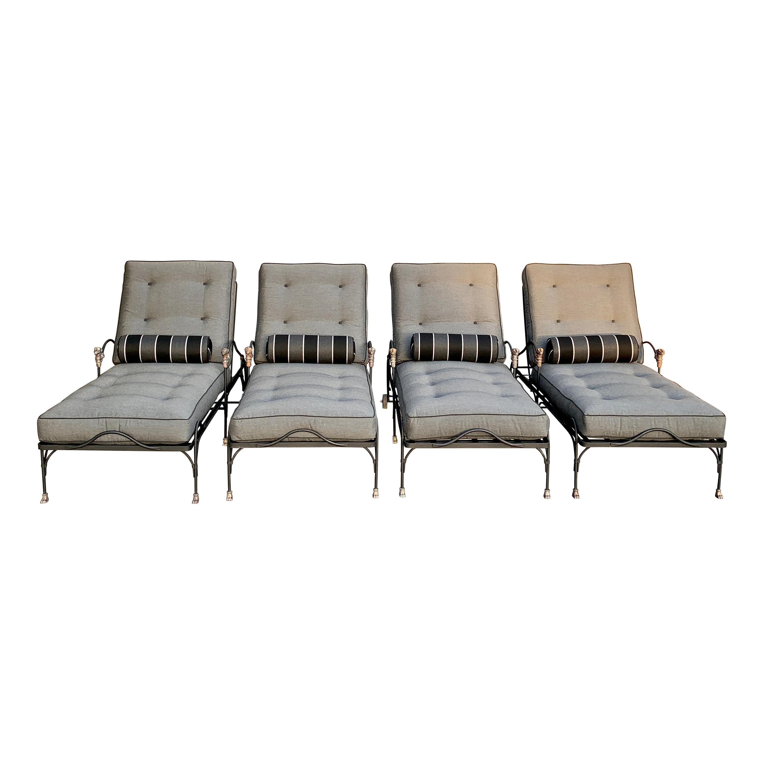 Four phenomenally designed outdoor wrought iron chaise lounges with sculpted head, paw feet and wheels sculpted of statuary bronze. The thoughtful design of the lounges has a curved handle at the base and head of the lounge for ease of movement. The