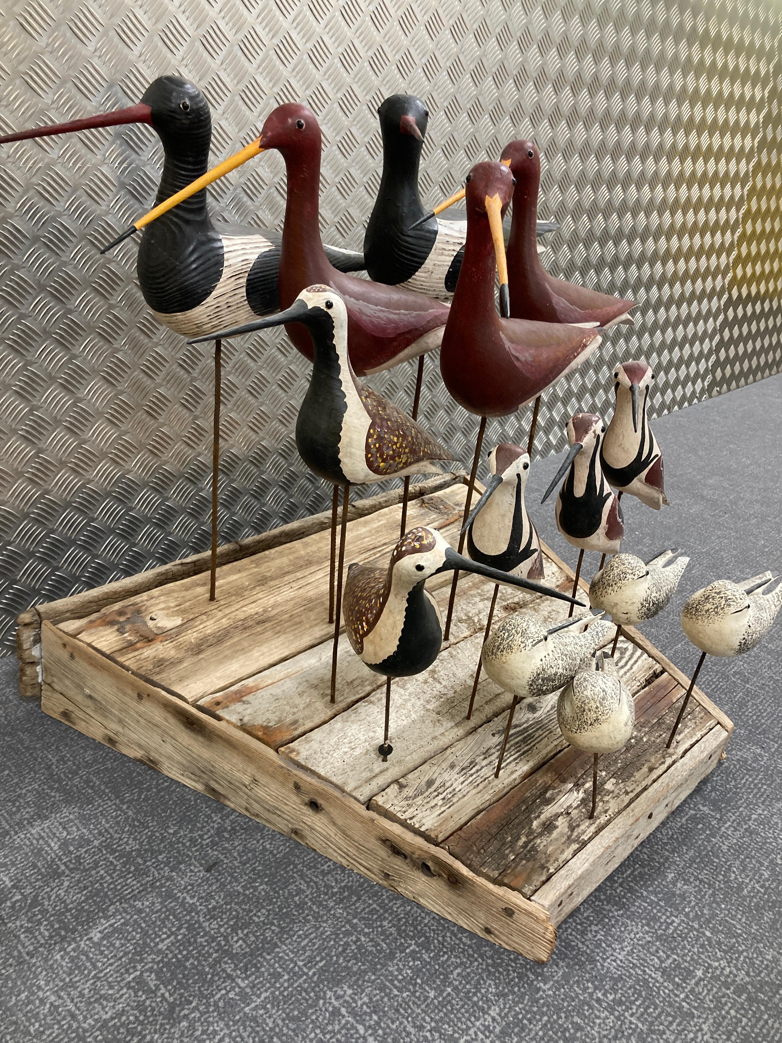 An original piece of English folk-art sculpture by the acclaimed British sculptor Guy Taplin (b. 1939). Eight individual wooden birds carved and painted, then  mounted to a driftwood base, each one signed and titled by the artist.  