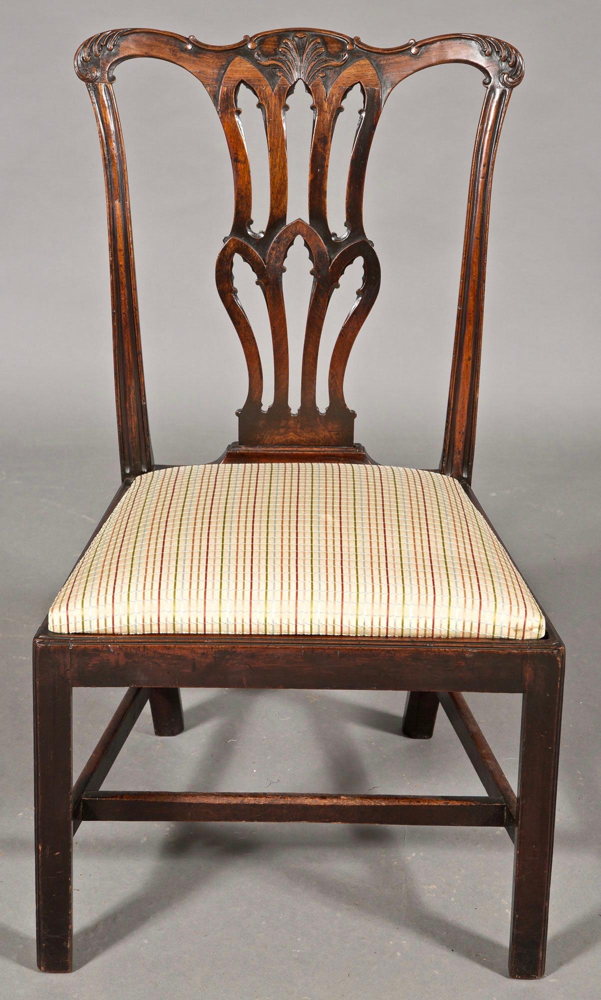Set of fourteen George III mahogany dining chairs.

One armchair and seven side chairs, circa 1760.
The armchair with serpentine cresting above a pierced backrest and drop-in seat flanked by shaped armrests, on tapering square legs joined by