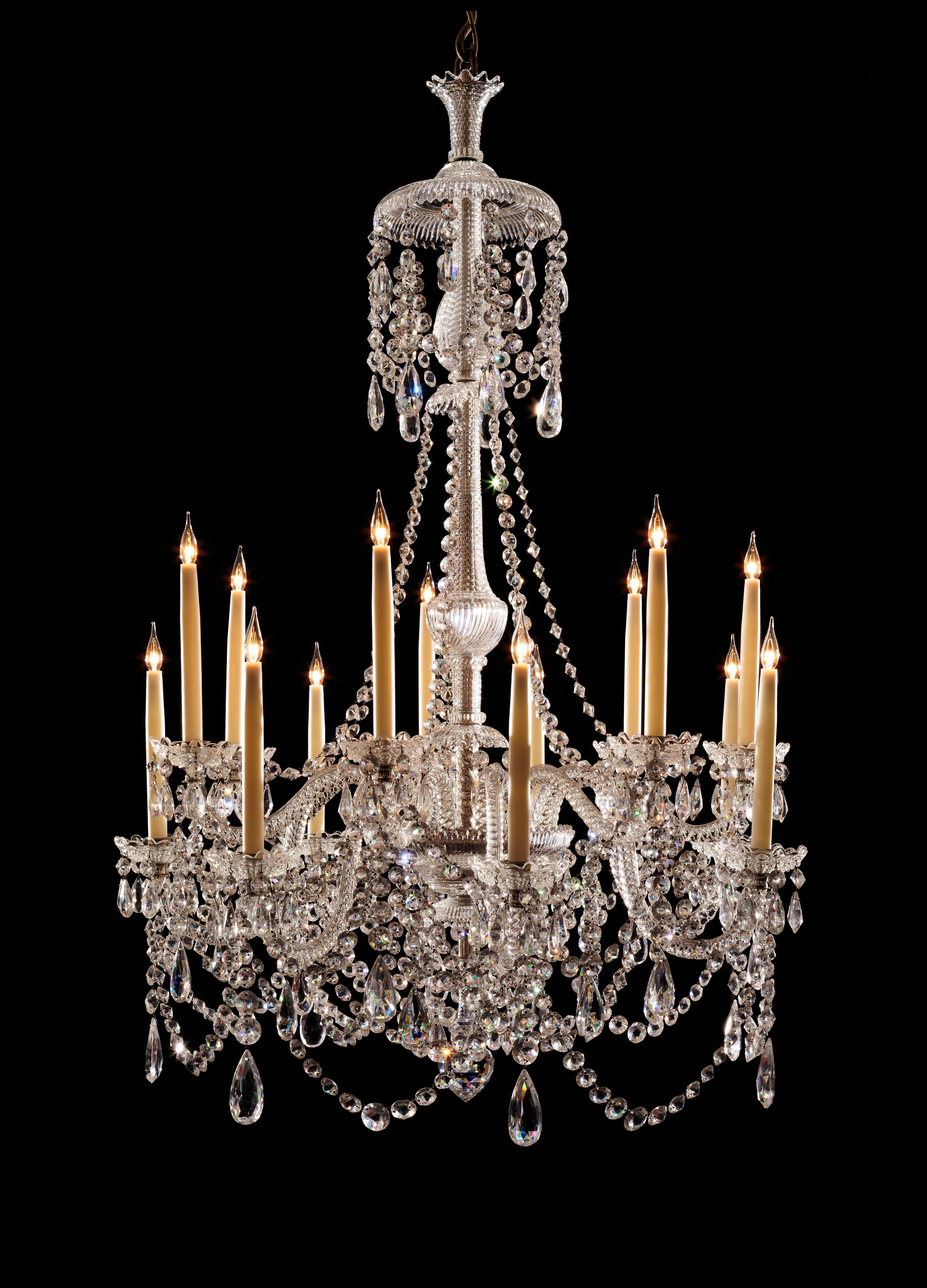 A stunning original Perry chandelier arranged on two tiers with seven solid lead crystal 's' arms and seven solid lead crystal kick arms and traditional “step” cutting on the central shaft pieces, dressed with swags of round double pointed buttons