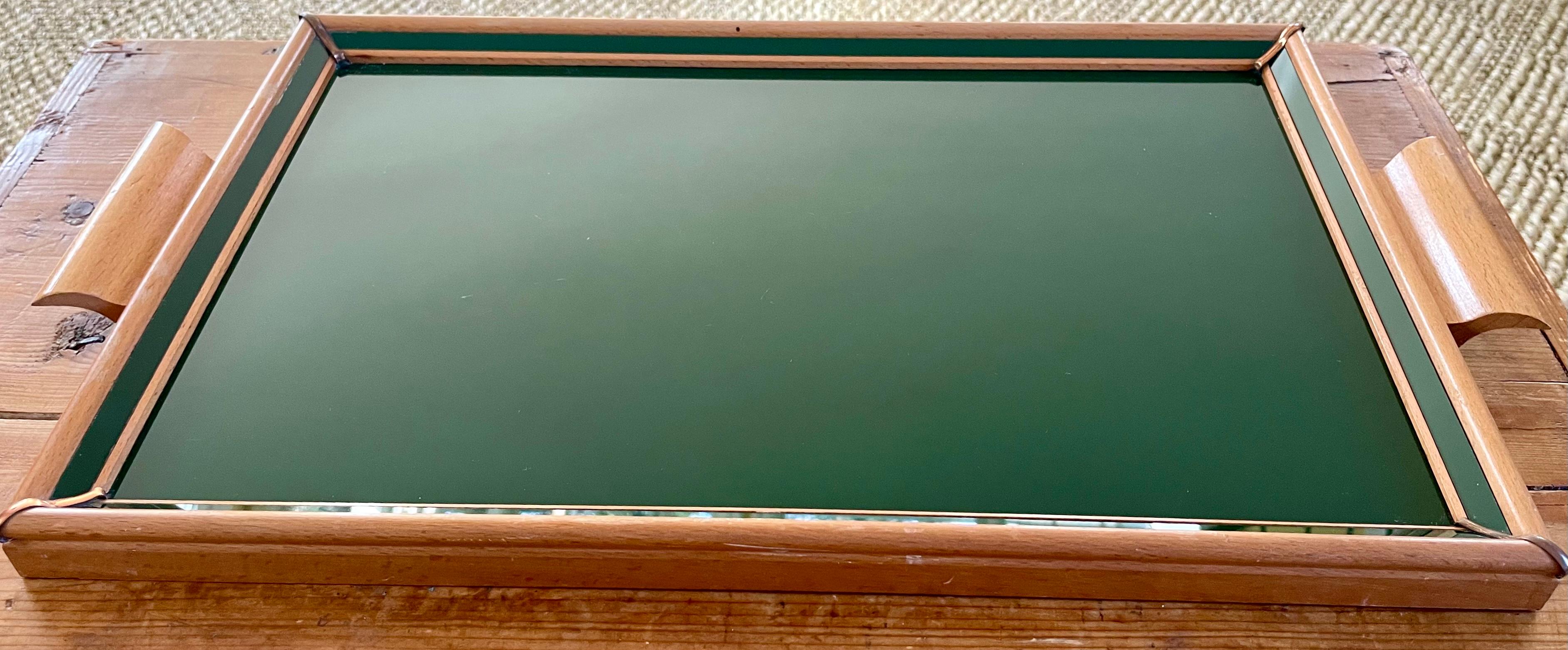 Forties Italian green glass and wood tray. Pale wood framed and handled glass serving tray with green under painted surface with additional angled glass bordering panels.
Dimensions: 20