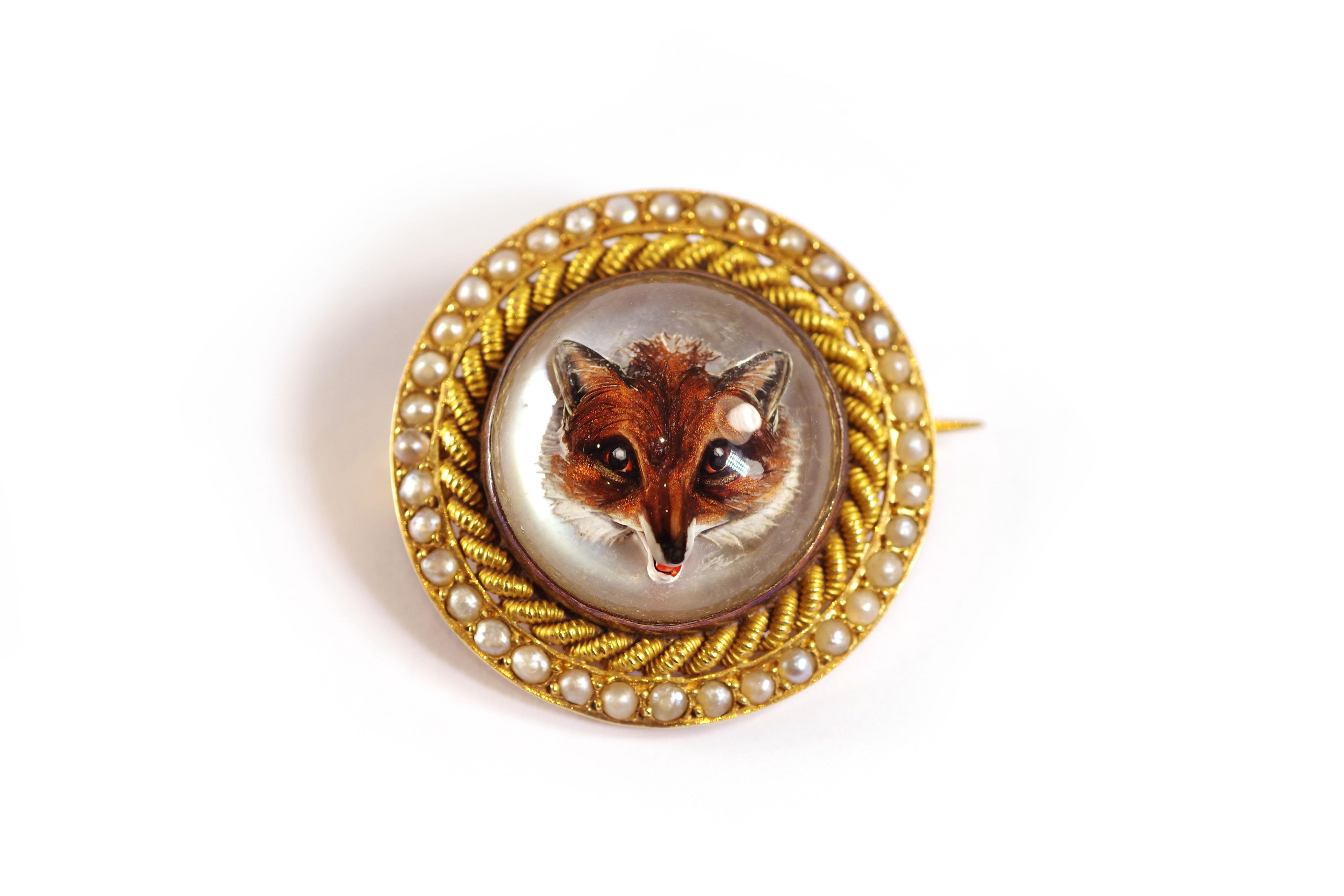 Fox crystal Essex brooch in 18 karat yellow gold. Antique English brooch with a large round Essex crystal, carved inside with a fox's head, on a white silvered background. The rock crystal is polished and in a closed setting, the outline of the