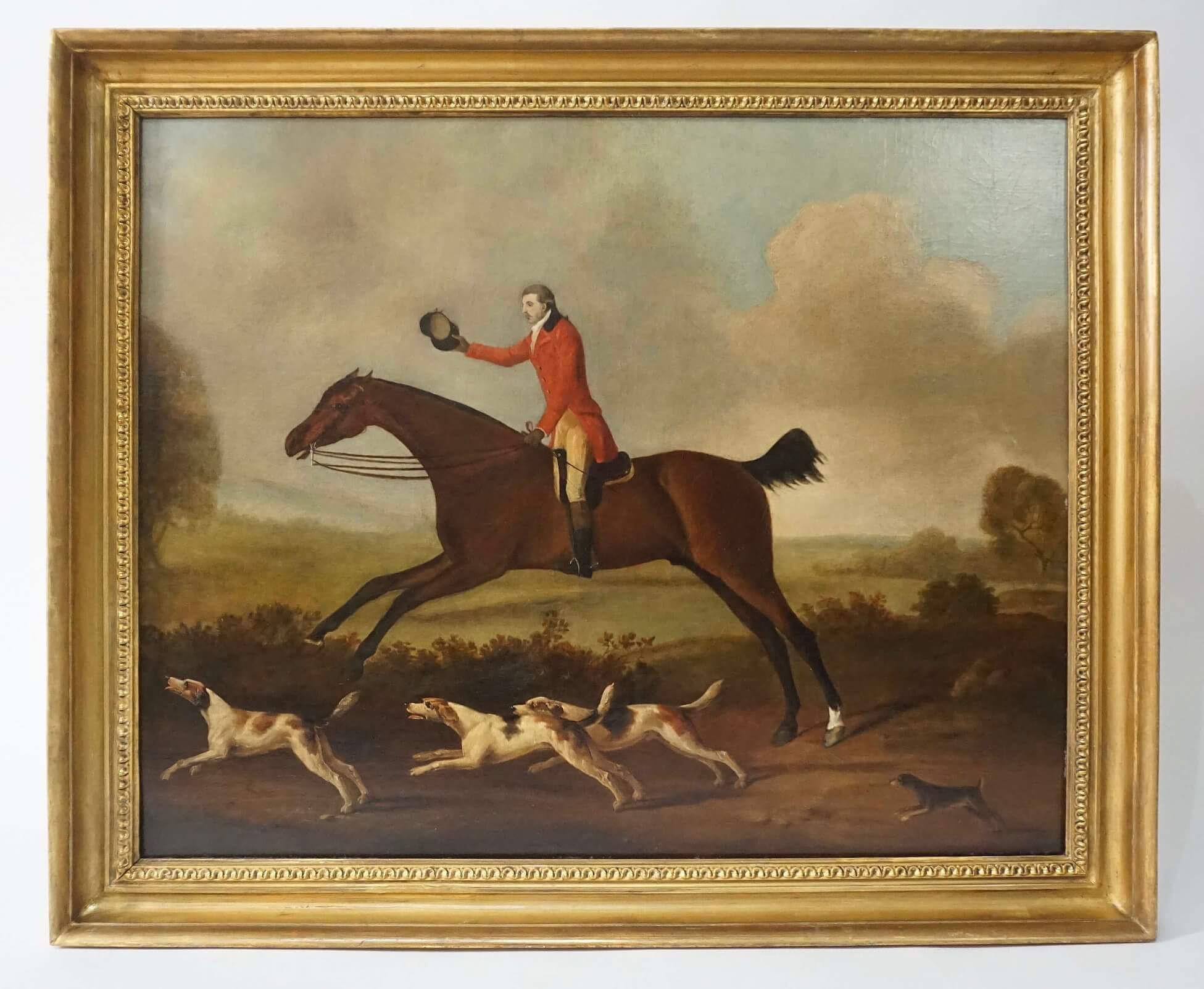 An exquisite circa 1790 equestrian oil on canvas of a red-coated and bewigged gentleman fox hunter with outstretched arm and hand holding cap, 'riding to hounds' on a galloping bay horse with three foxhounds at lower left and  puppy lower right