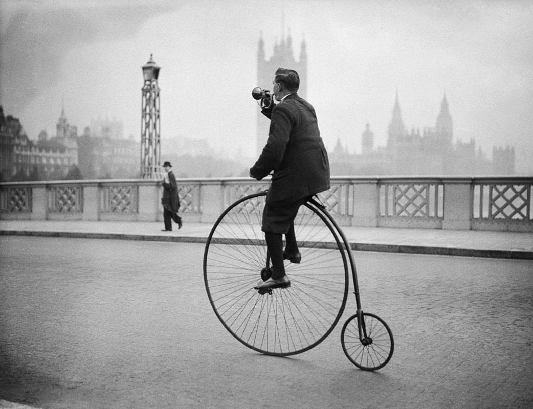 "Penny Farthing Bugle" by Fox Photos

17th October 1932: Edwin Davey, riding a penny farthing bicycle over Lambeth bridge in London, and blowing a bugle to warn of his approach.

Unframed
Paper Size: 20" x 24'' (inches)
Printed 2022 
Silver Gelatin