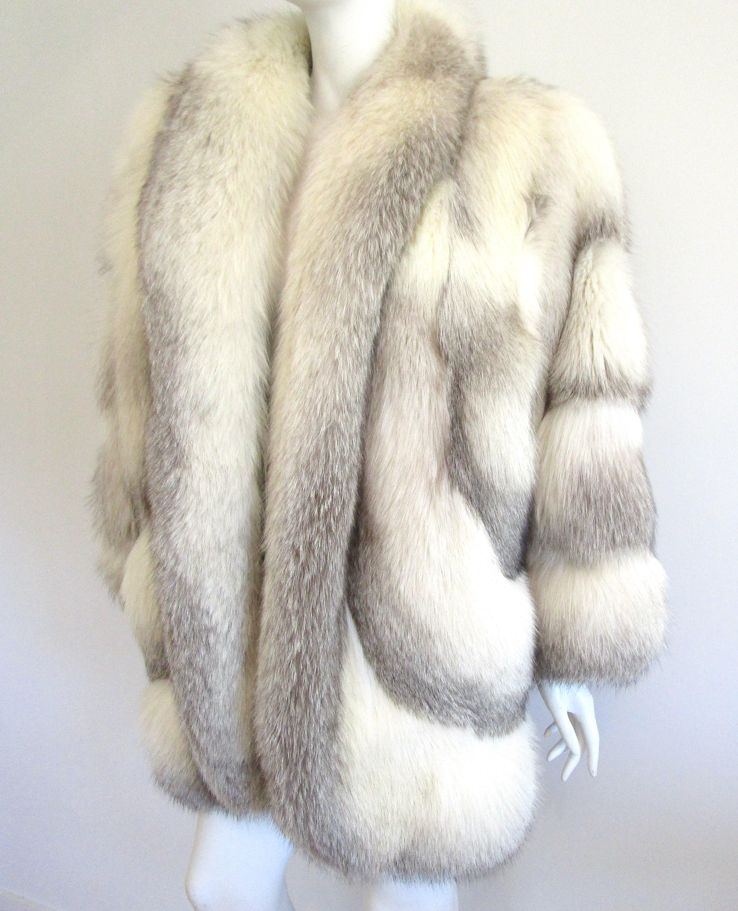 Stunning White and silver tipped fox jacket. Detailing is amazing, scalloped edge on the bottom of the jacket. Dolman sleeves. Slit pockets. One hook and eye closure. Simple Grey lining. Fur is soft and supple. Lining needs a bit of a mend (photos)