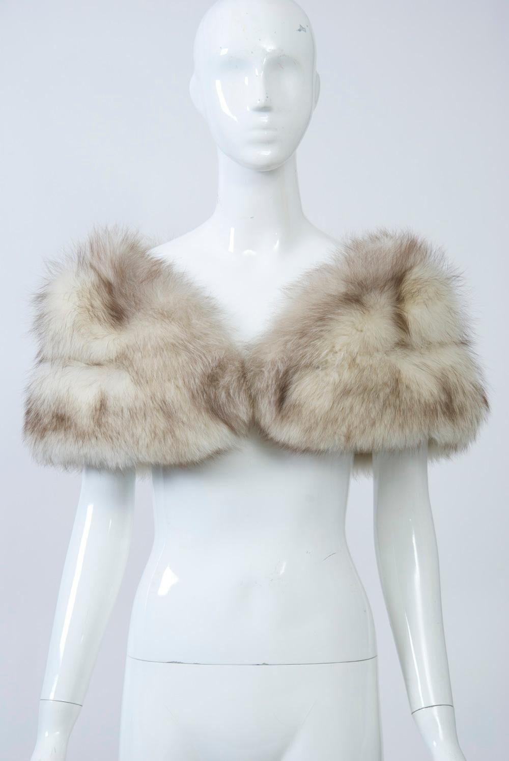 Double-skin fox stole is the perfect wrap for evening, weddings, etc. Beige satin lining with hand compartments. Fur hooks allow for adjustability. A great and indispensable accessory.