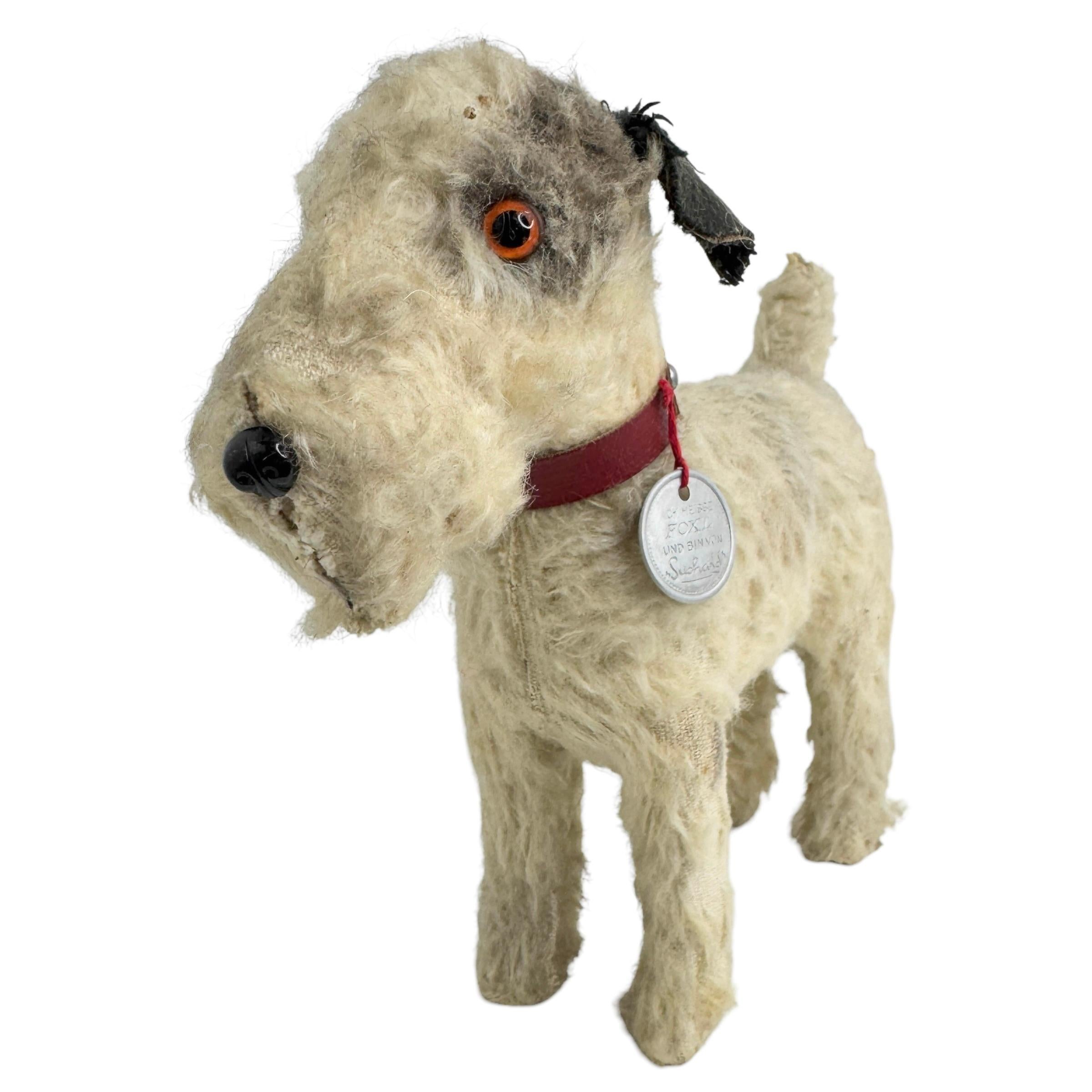 A beautiful dog candy container. Made of paper mache, covered with mohair and has glass eyes. Nice addition to your Christmas or new years collection or decoration. It is from the 1930s or older. Offered from the famous Suchard Company. This company