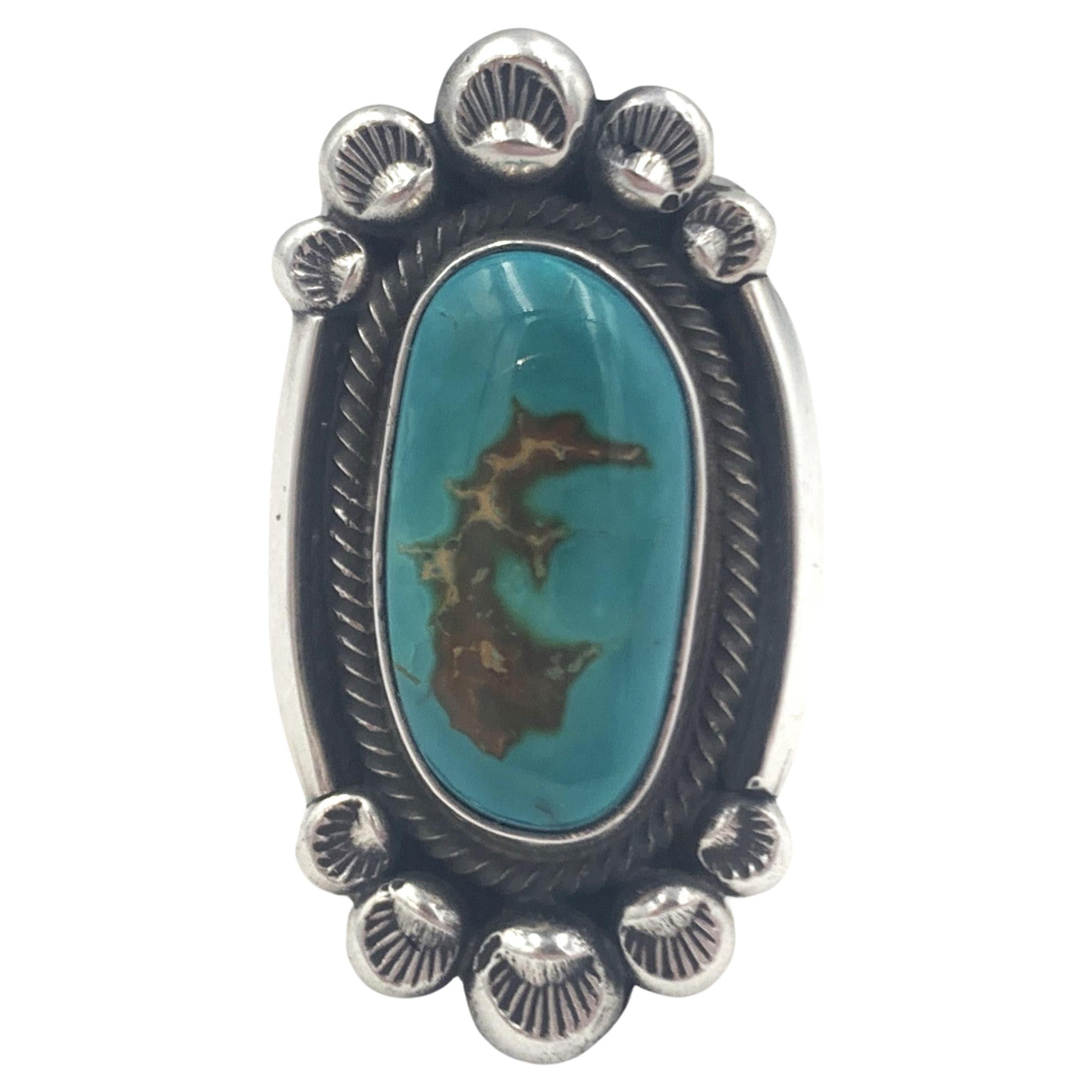 Fox turquoise sterling silver ring by Navajo silversmith Leon Martinez.  The 3/8” x 3/4” Fox turquoise cabochon is in a beautiful hand stamped setting; the band is 3/8”.  

Size: Adjustable from 8.5 to 13.5

The Fox Turquoise mine, once called the