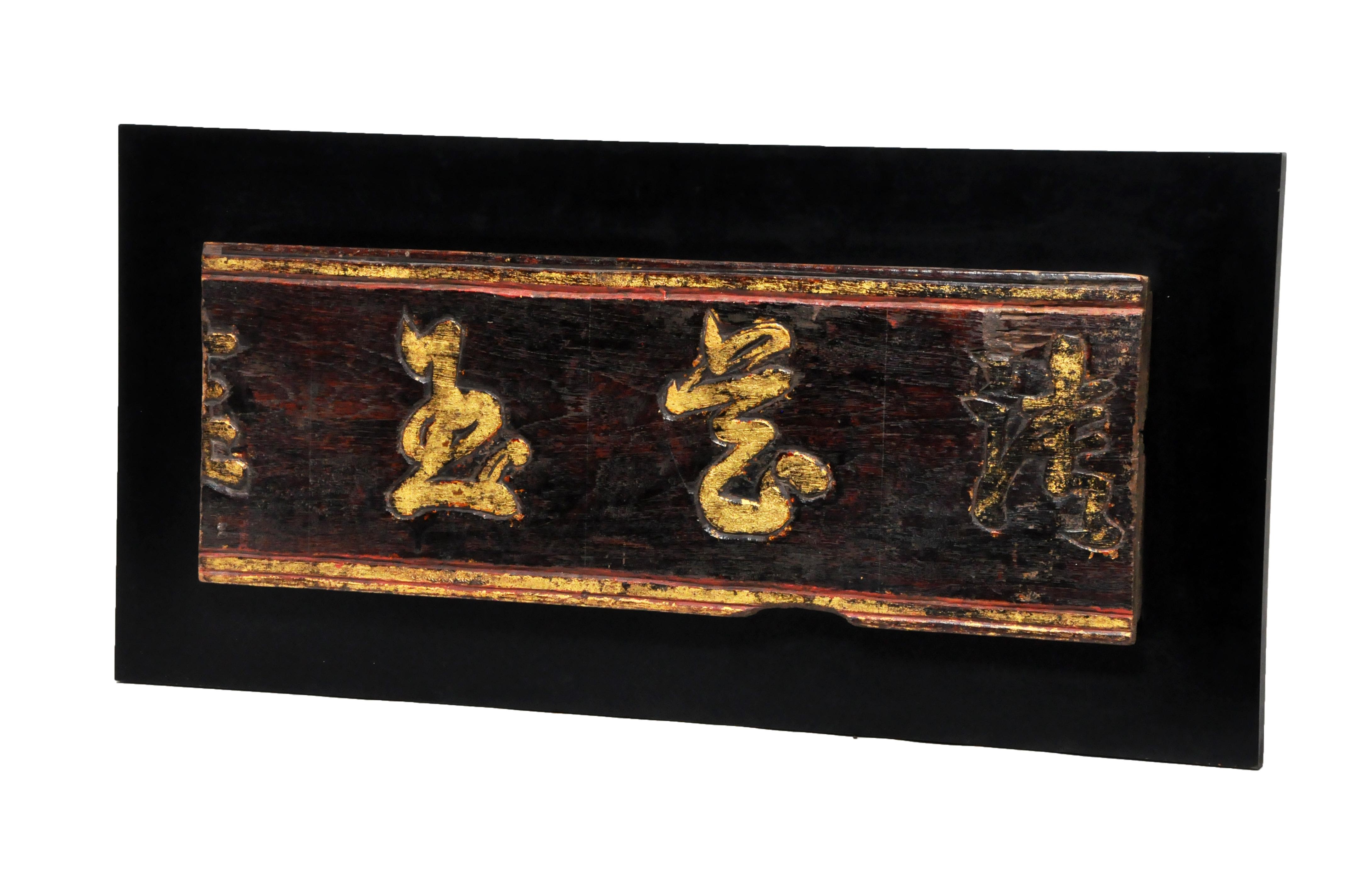 The sign is of Burmese origin, made from teakwood and covered in lacquer and gold leaf. The two legible characters are “Jade” and “Art”. As many carved signs were shop signs, this may have been a jade dealer’s sign. The piece is estimated to be