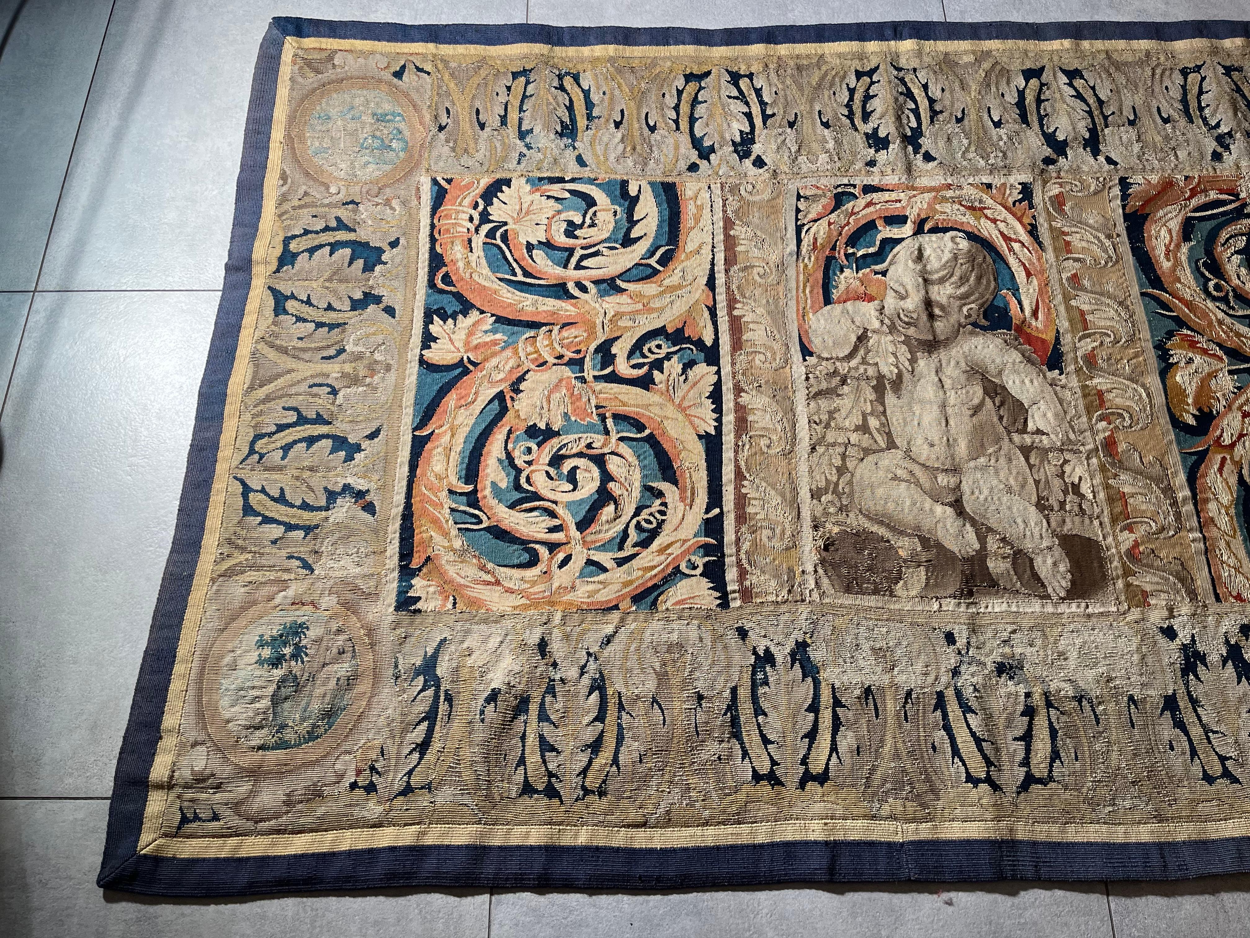 Fragment of Flemish tapestry from the 17th century.
This tapestry fragment depicts a mythological angelic child in the center. On either side we find two columns of golden acanthus scrolls as well as at the back of the angel in a background of blue