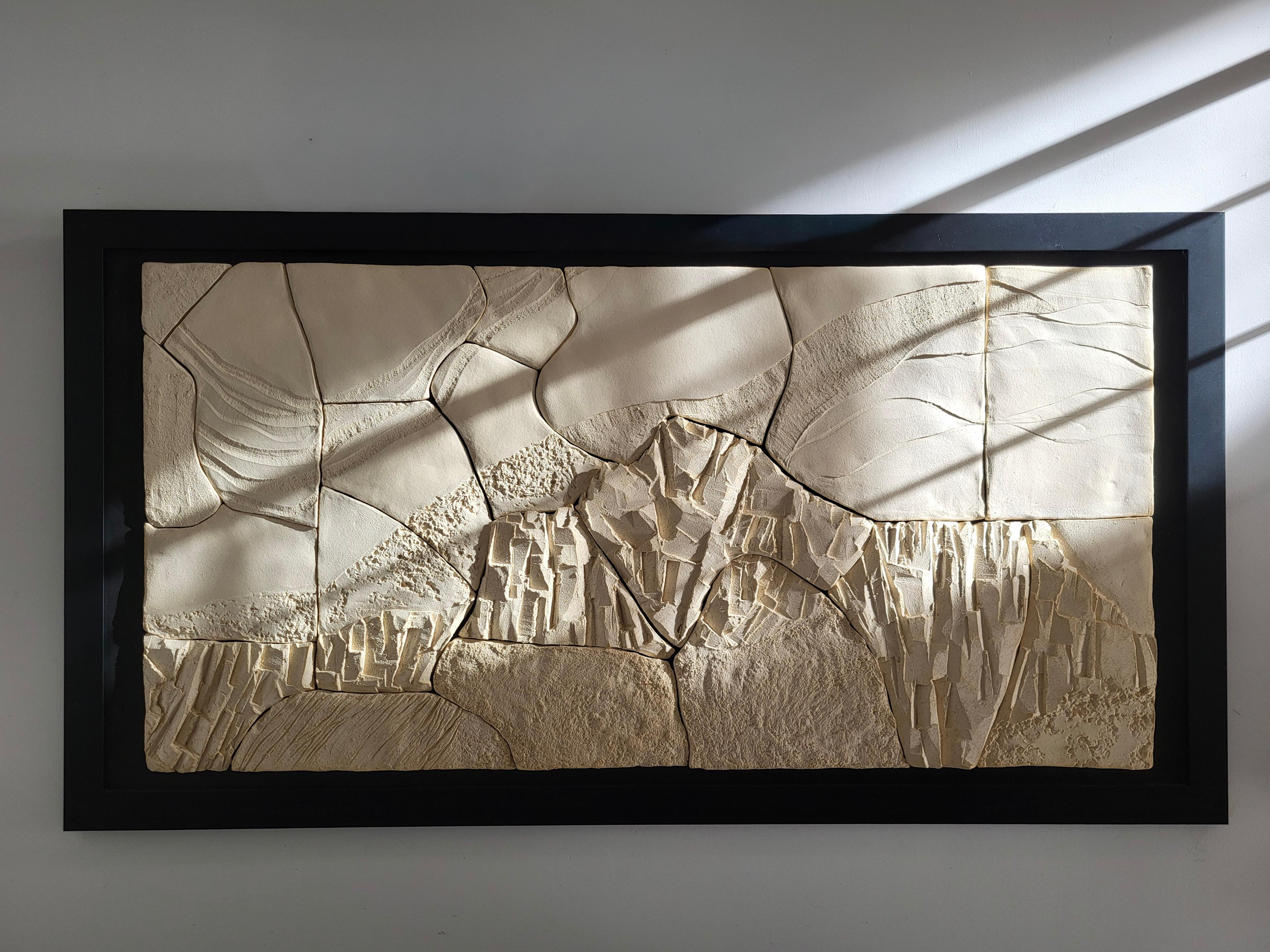 Fragmented Landscape I ist eine keramische Wandskulptur der französischen Künstlerin Audrey Vo Van, die aus handgefertigten Schamotte-Steinzeugfragmenten besteht, die auf einer gebeizten Holzplatte montiert sind. Jeder Abschnitt ist Teil einer