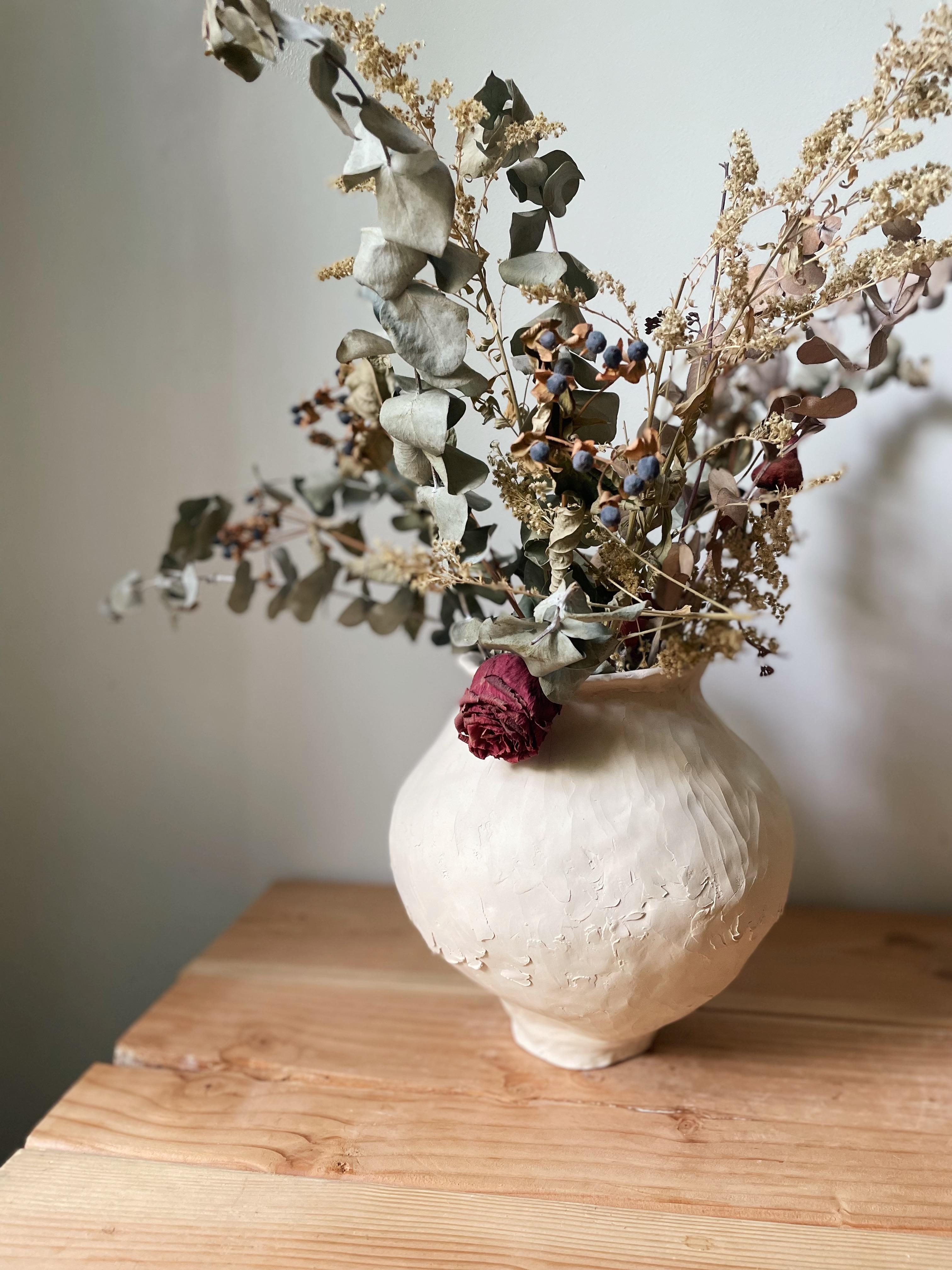 The Frai vessel was hand-built by taking bits of clay and smooshing them together, while shaping as the clay drys into its round form. Always accepting any imperfections along the way, this piece has a soft voice and works great in all settings. The