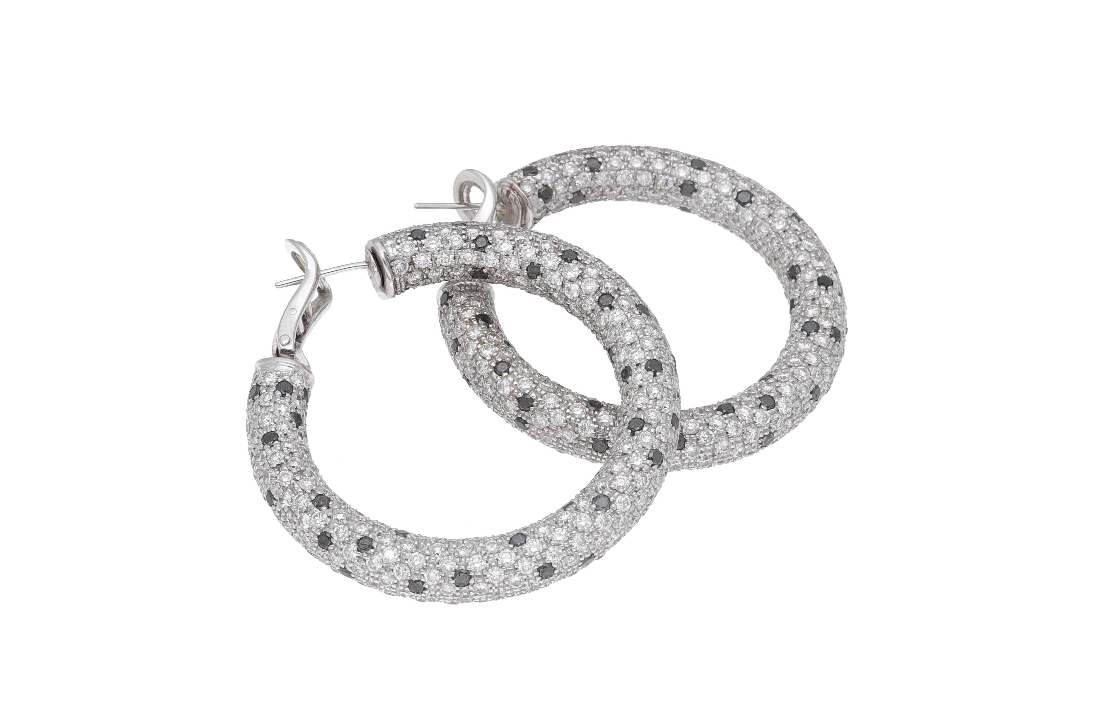Hoop earrings made entirely by hand in Italy of 18 kt. white gold with white diamonds and black diamonds.
These circles are made with a pavé setting and are one of a kind.
Diamond Fraleoni Collection.
The alternation of white and black diamonds