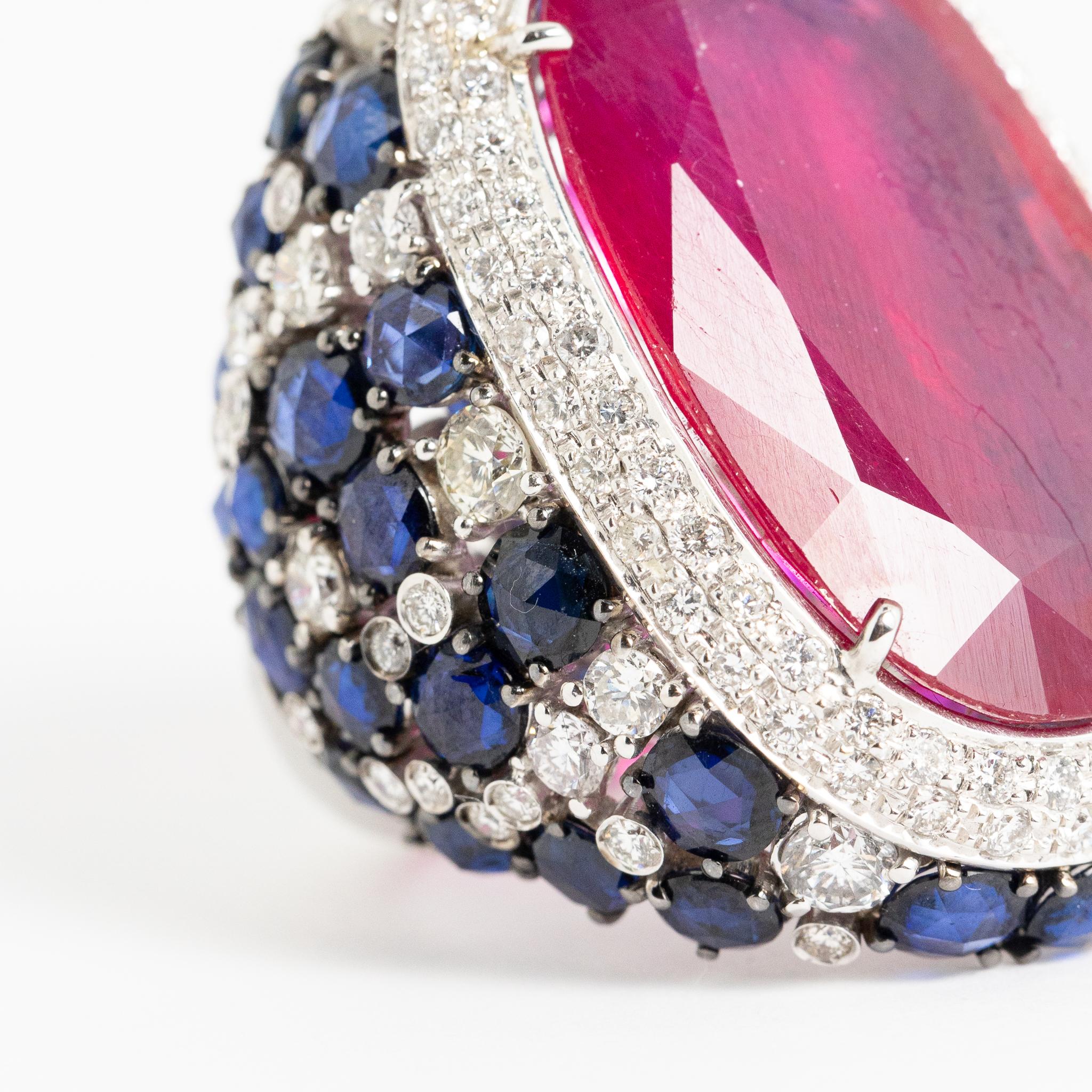 Ring made of 18 kt. white gold with diamonds, blue sapphires and glass-filled ruby signed Fraleoni.
Entirely handmade in Italy, one of a kind.
This piece features sapphires and diamonds on the ring setting and an oval-cut ruby in the center.
A
