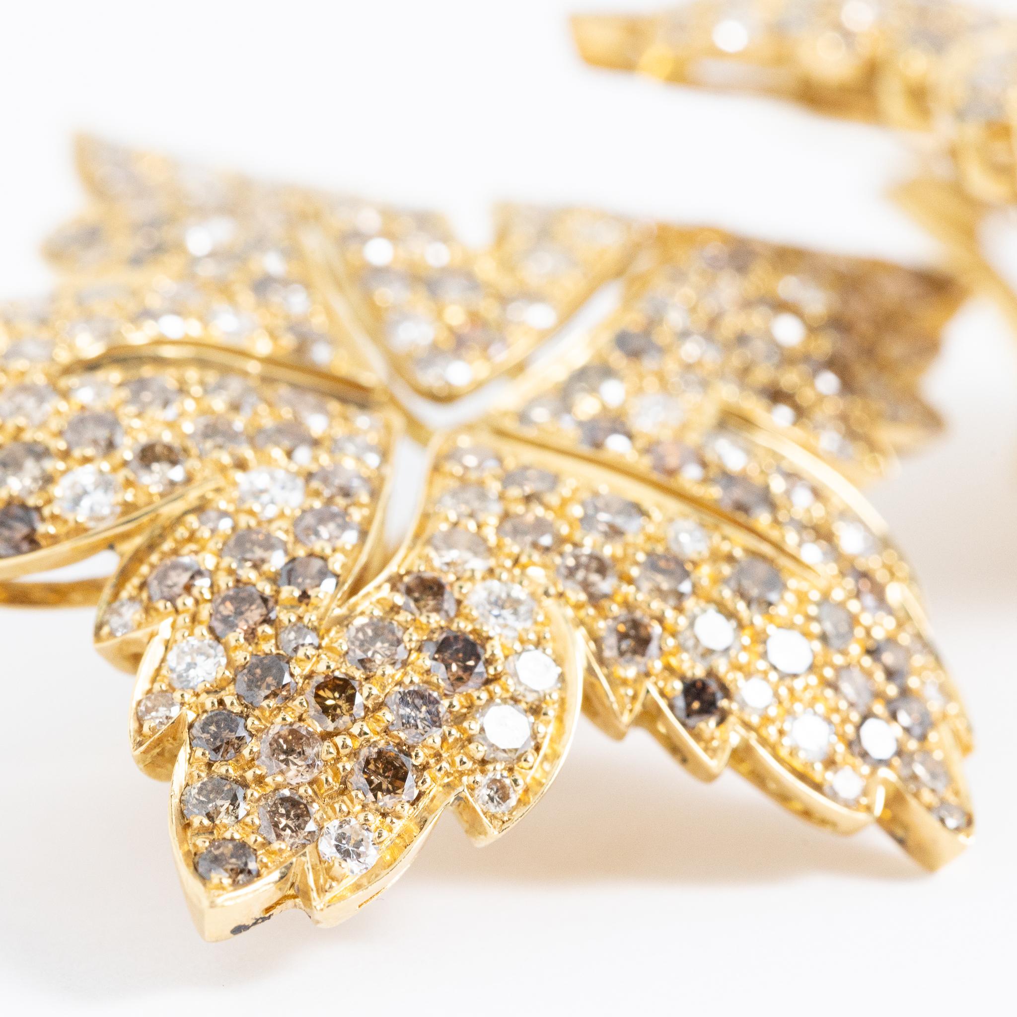 Boucles d'oreilles faites à la main en Italie en or jaune 18 carats avec des diamants blancs et bruns de taille brillant.
Cette pièce appartient à la collection Dolcevita de Fraleoni.
Les boucles d'oreilles sont conçues comme une feuille et