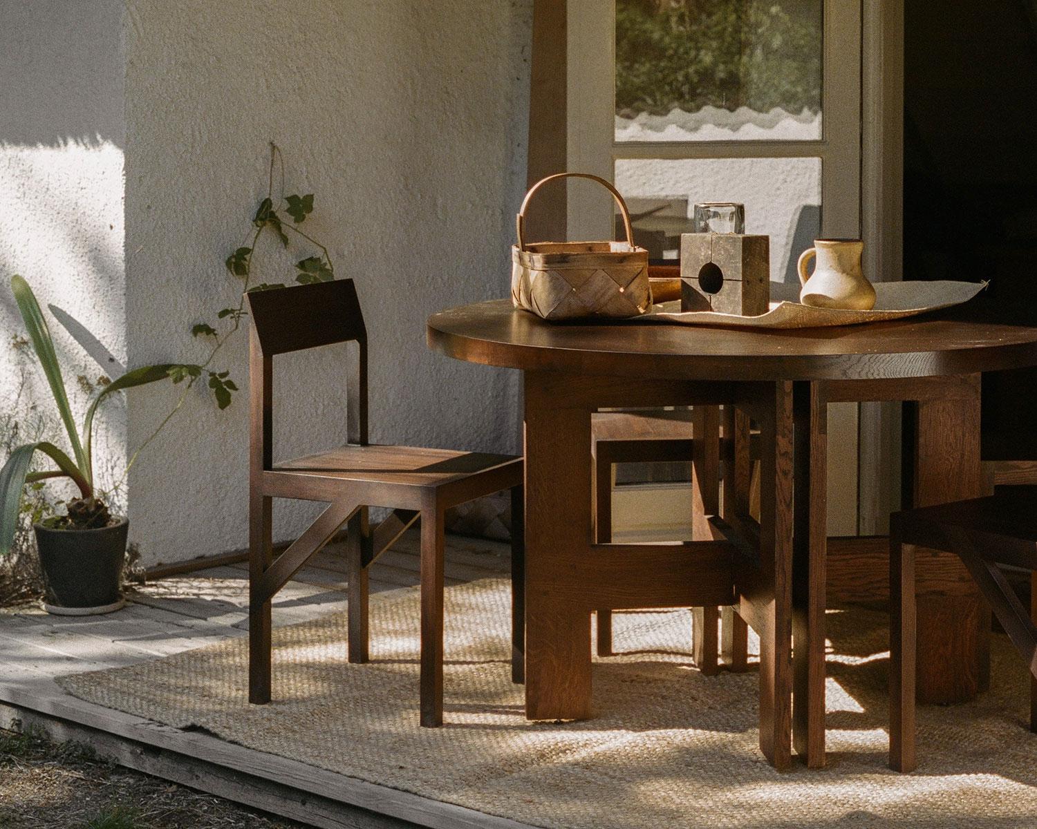 La Bracket Chair en frêne foncé, conçue en collaboration avec le studio de design Frederik Gustav basé à Copenhague, est une pièce à quatre pieds fabriquée en frêne massif laqué à base d'eau, avec une assise plate et un dossier légèrement incliné