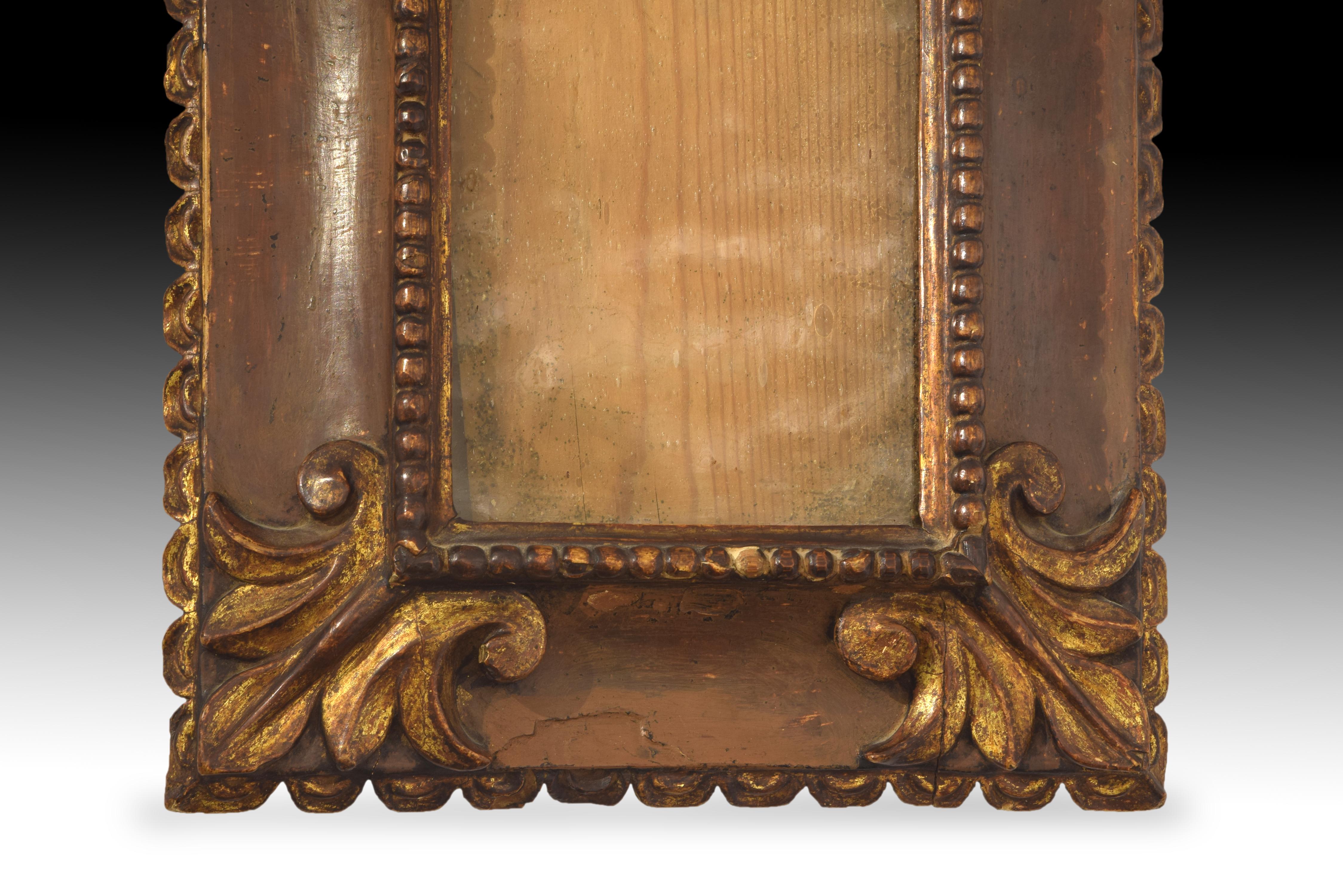 Rectangular frame of carved wood decorated with reliefs arranged in three bands (inside, a string of pearls, then a wider band with prominent plant motifs in the corners in symmetrical arrangement, to the outside waves that end in points towards the