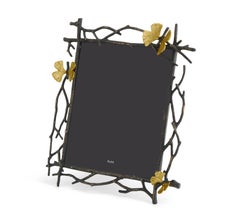 Cornice con motivi di Ginkgo e farfalle in metallo ossidato e dorato.