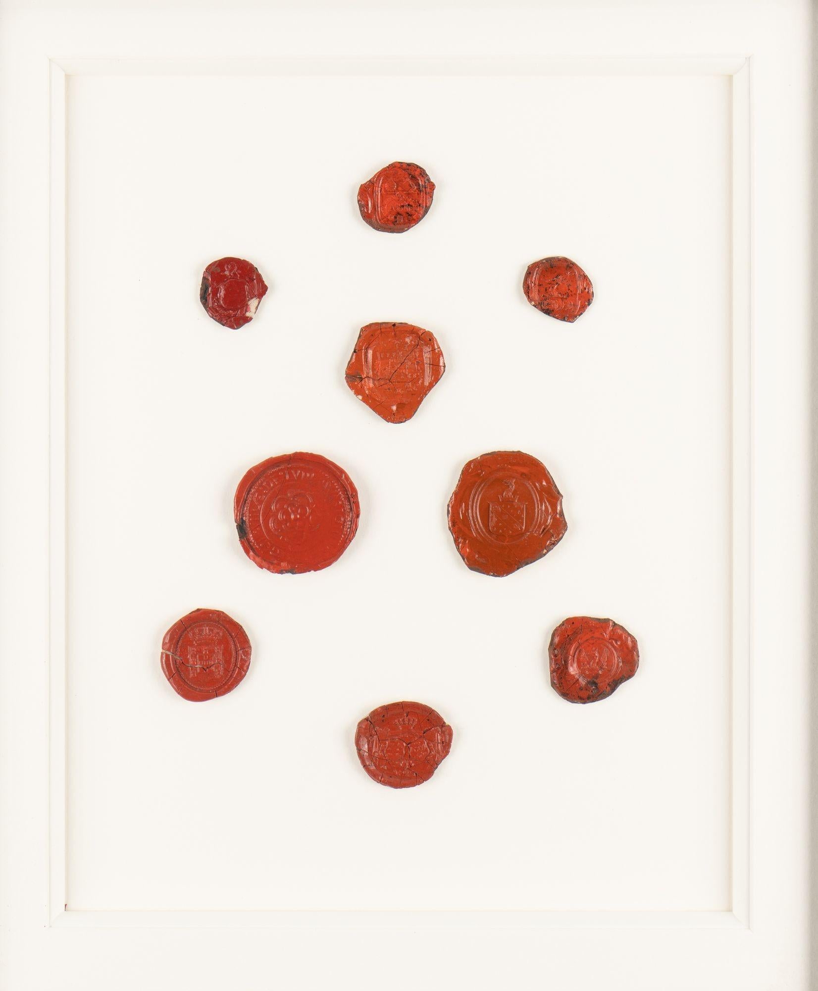 Set of nine 18th century English red wax seals on paper and mounted in an ebonized pie crust frame.