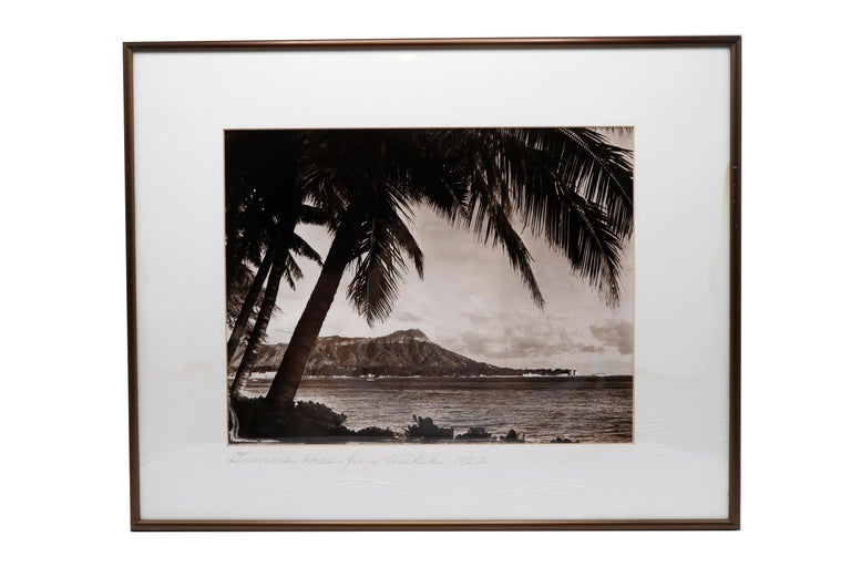 A set of three framed photographs of Hawaii dating from the 1920’s. Each has an inscription in pencil in verso; Diamond Head from Waikiki, 1922, Hawaiian Women and Lei Sellers Set Up On a Sidewalk. Photographs are set in a wide white matte in a