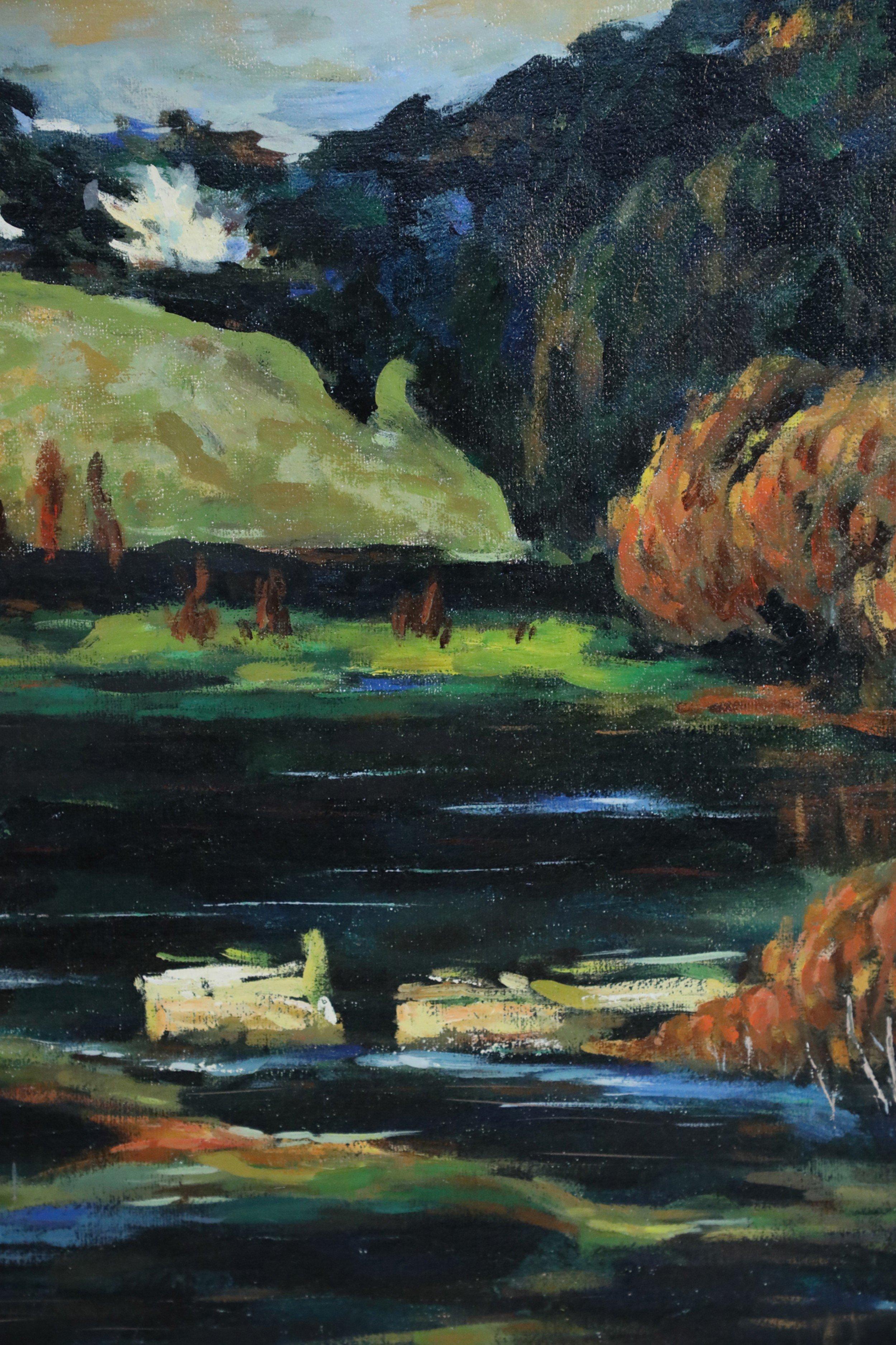 Mid-century acrylic landscape painting of a reflective lake in the foreground surrounded by white stone buildings with a hilltop in the background surrounded by autumn trees on canvas in a rectangular black painted wooden frame.