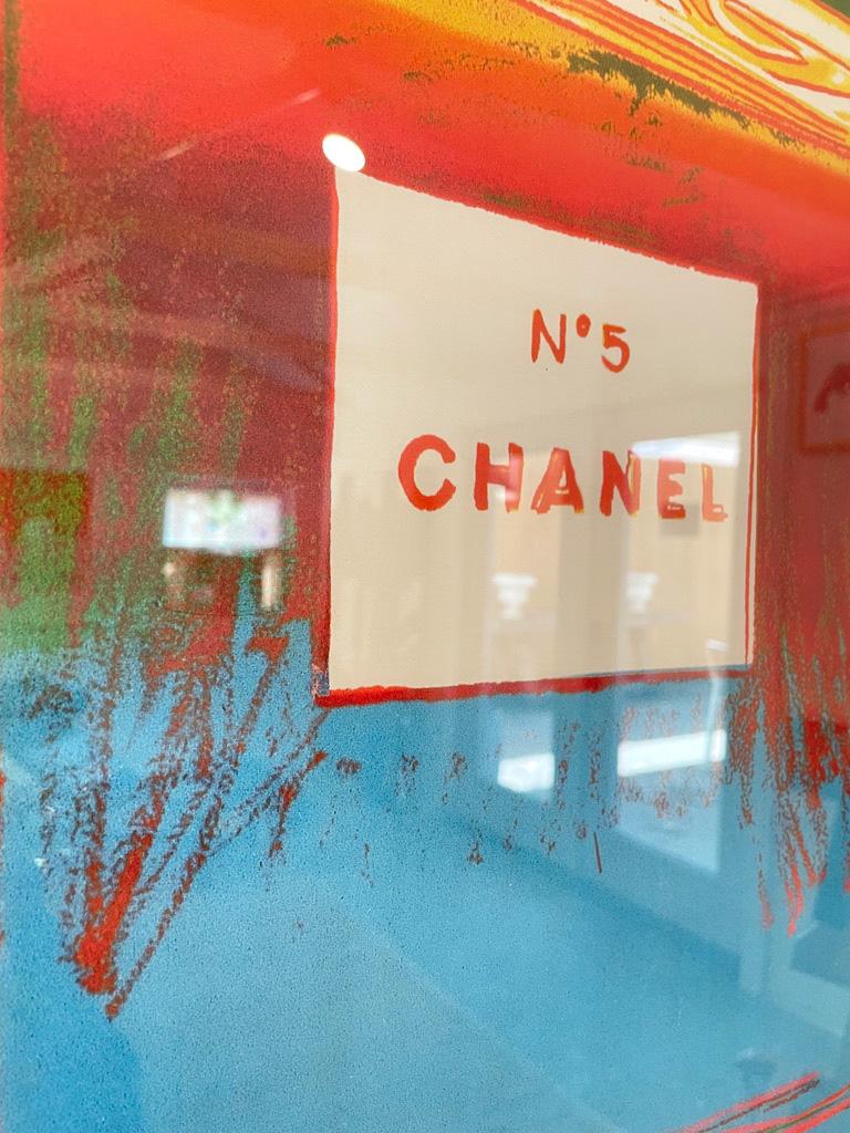 This Beautiful iconic vintage pop art Chanel poster is presented with a modern white frame and has a green and blue background and red lettering. This poster is mounted on linen and is by Andy Warhol, depicting the luxurious Chanel No. 5 perfume