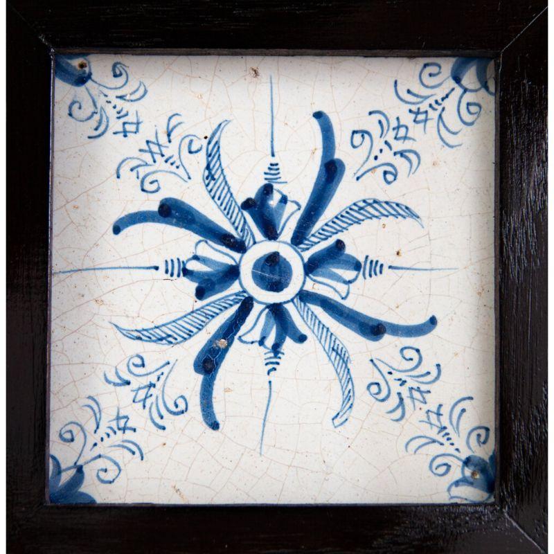 A superb antique Dutch Delft hand painted floral aigrette decorative tile in a custom oak frame made in the city of Haarlem, circa 1650. This lovely tile depicts a floral and feather design in vibrant cobalt blue paint and is in amazing condition