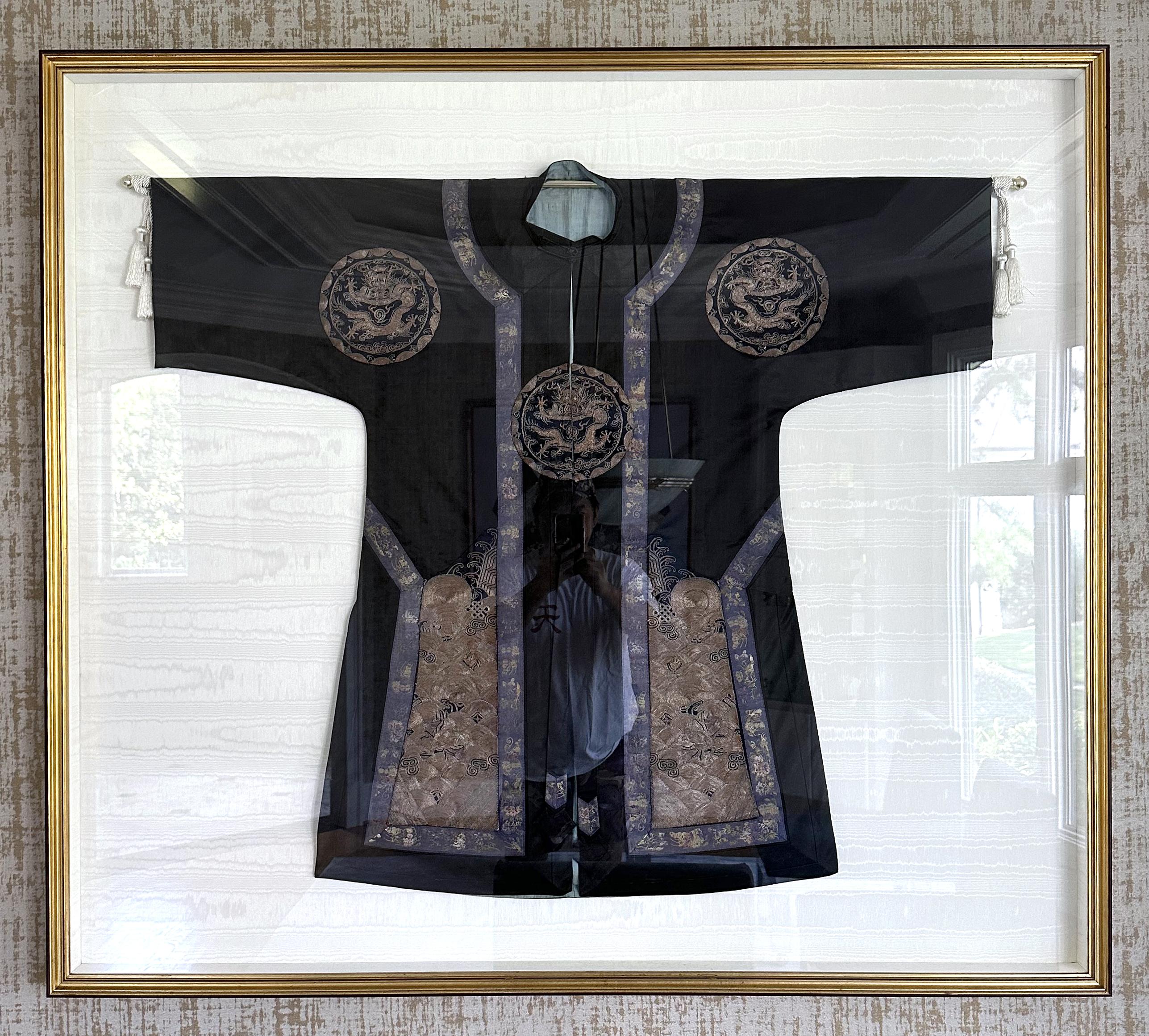 A black silk robe with three medallions of five-clawed dragons and thousands of ocean waves borders, all done in a splendid embroidery with gold bullion threads. A well-preserved piece of textile art dated to end of Qing Dynasty, circa late 19th