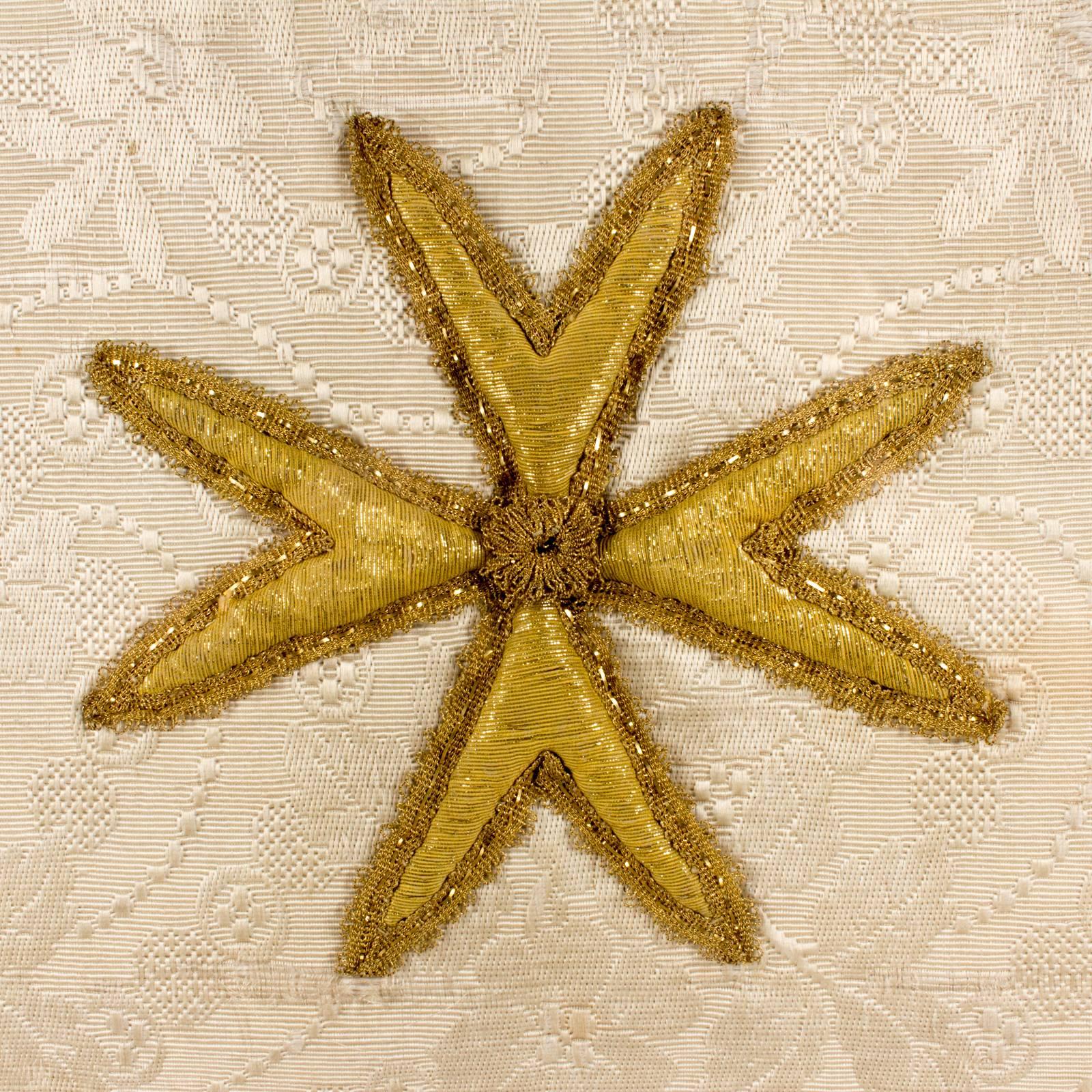 This beautifully made antique (late 1800s) textile fragment features a gorgeous embroidered cross in gold thread on a field of aged, ivory damask. This piece was uncovered recently in France. We had it framed in a very simple metallic frame which is