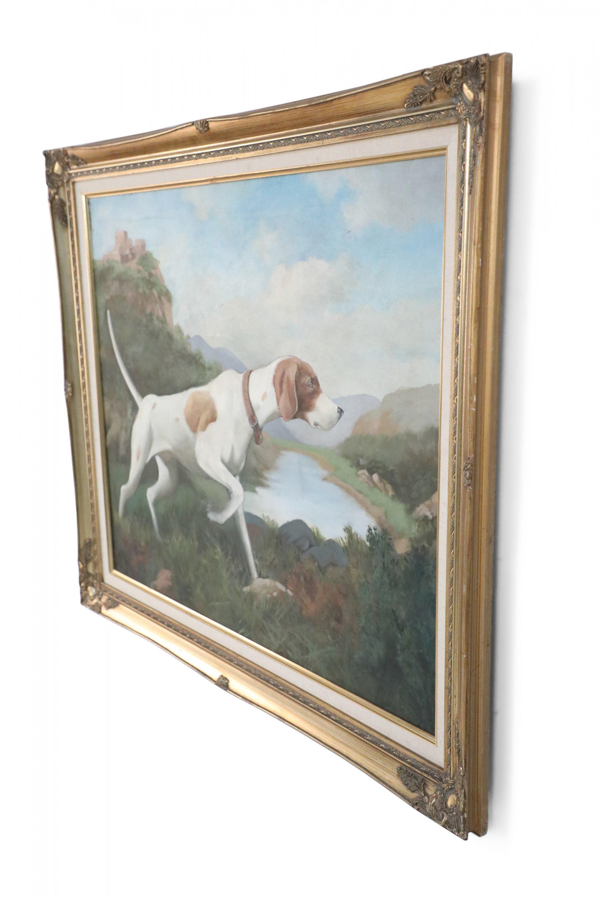 Vintage (20th Century) gold-framed painting of a brown and white hunting dog captured in a pointing stance, with a lake in the background and village in the distance.