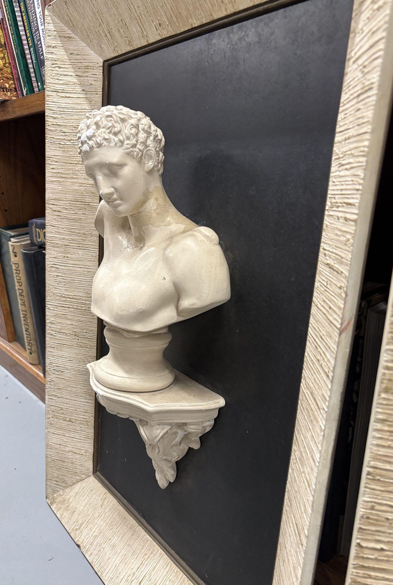 This striking pair of framed bust sculptures showcases classical-style male and female figures in a captivating three-dimensional design. Encased in elegant frames, these relief-style artworks exude timeless sophistication, bringing depth and