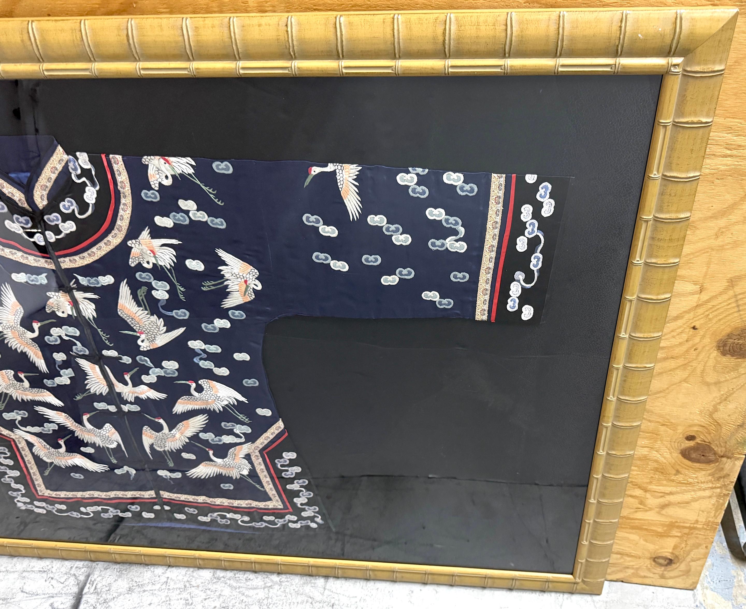 Robe chinoise encadrée en soie brodée de grues volantes et de nuages auspicieux, vers le début du 20e siècle

Exemple stupéfiant de l'art textile chinois, cette robe de soie richement brodée est présentée dans un cadre de style musée. La robe