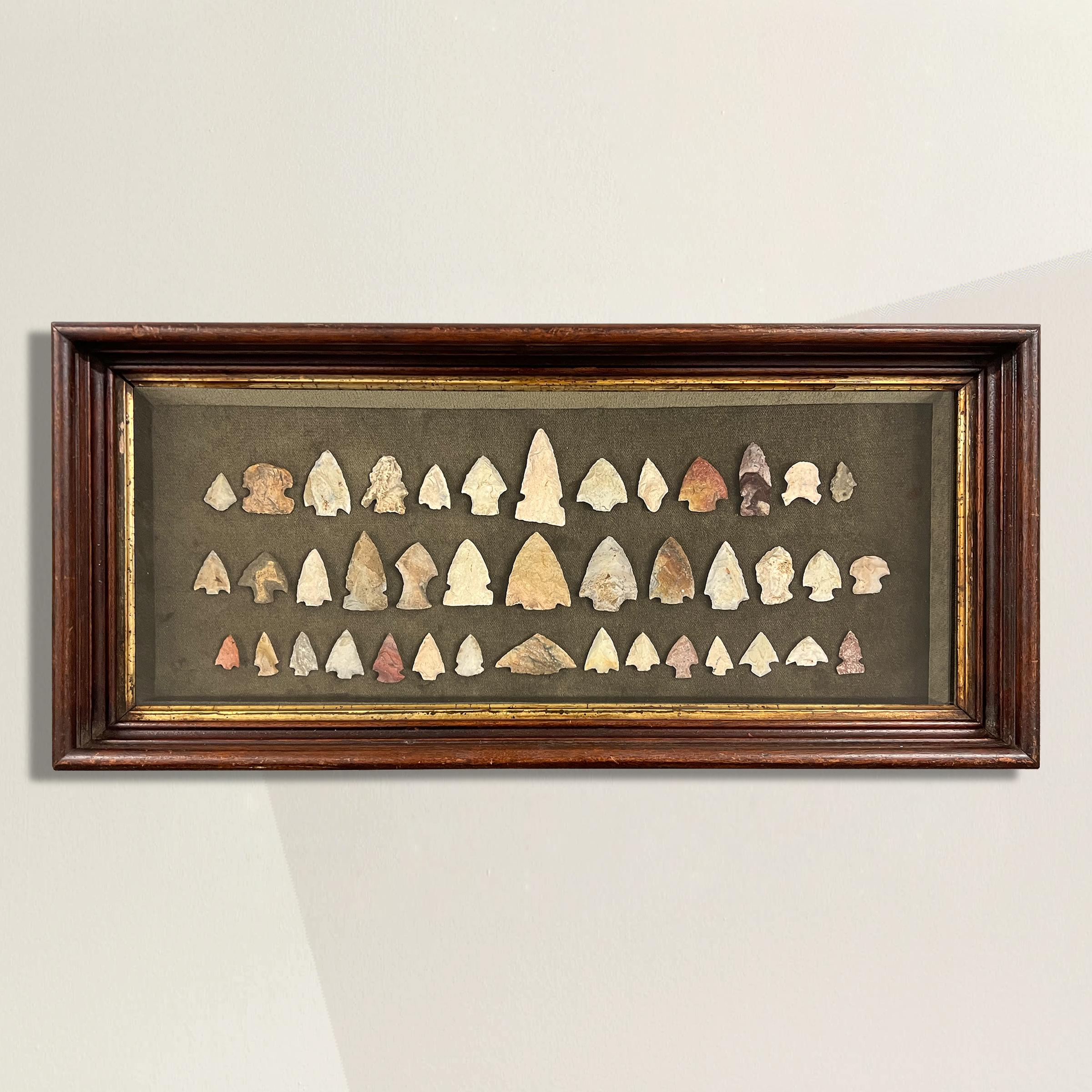 A captivating set of forty-one arrowheads found in Wisconsin's Waukesha County, mounted and framed in a 19th century shadowbox. These arrowheads, crafted by the skilled hands of Native American artisans, carry with them the echoes of an ancient