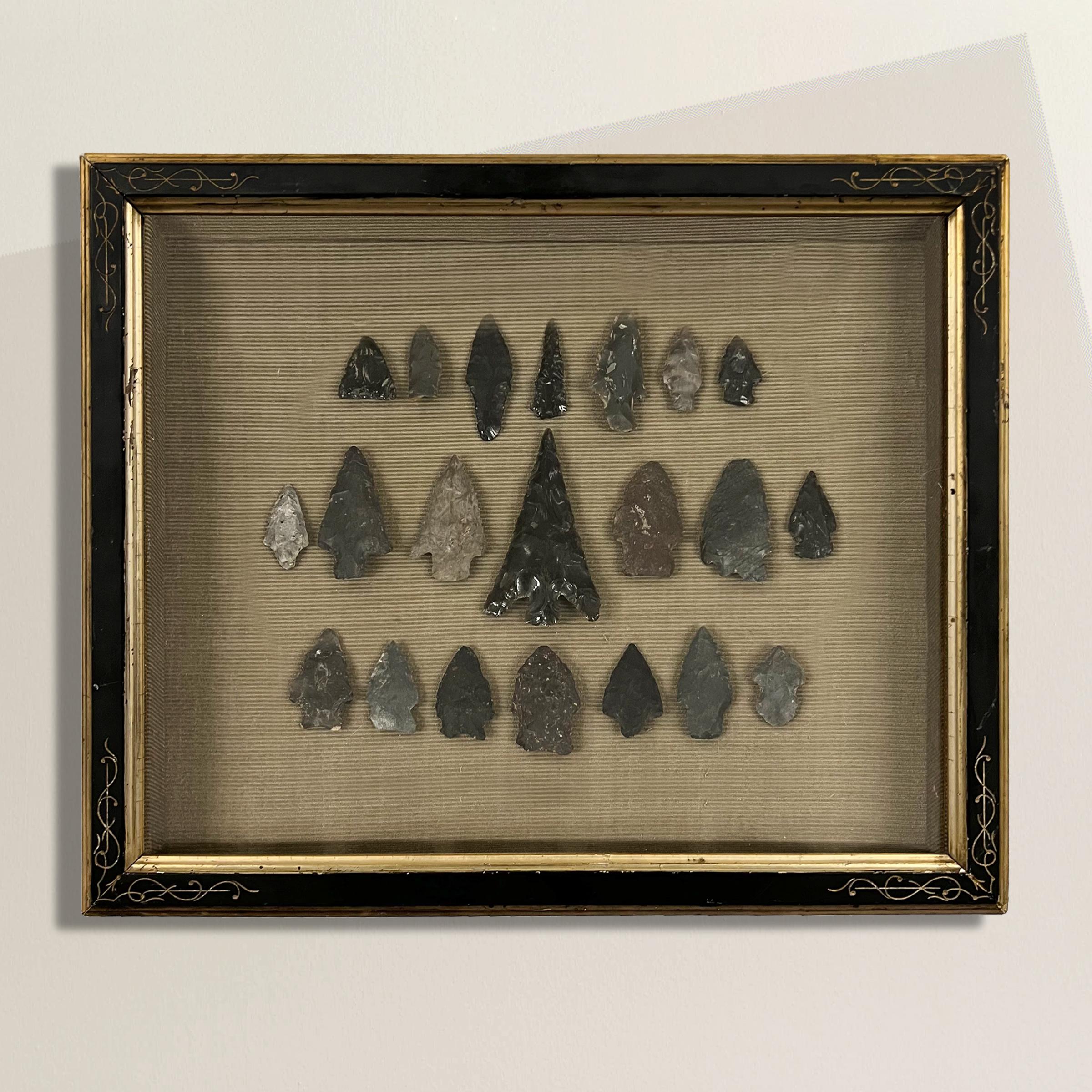 An exceptional set of twenty-one obsidian and flint arrowheads, discovered in Wisconsin's Waukesha County and framed within a 19th-century ebonized Eastlake shadowbox, these arrowheads not only capture the beauty of their craftsmanship but also