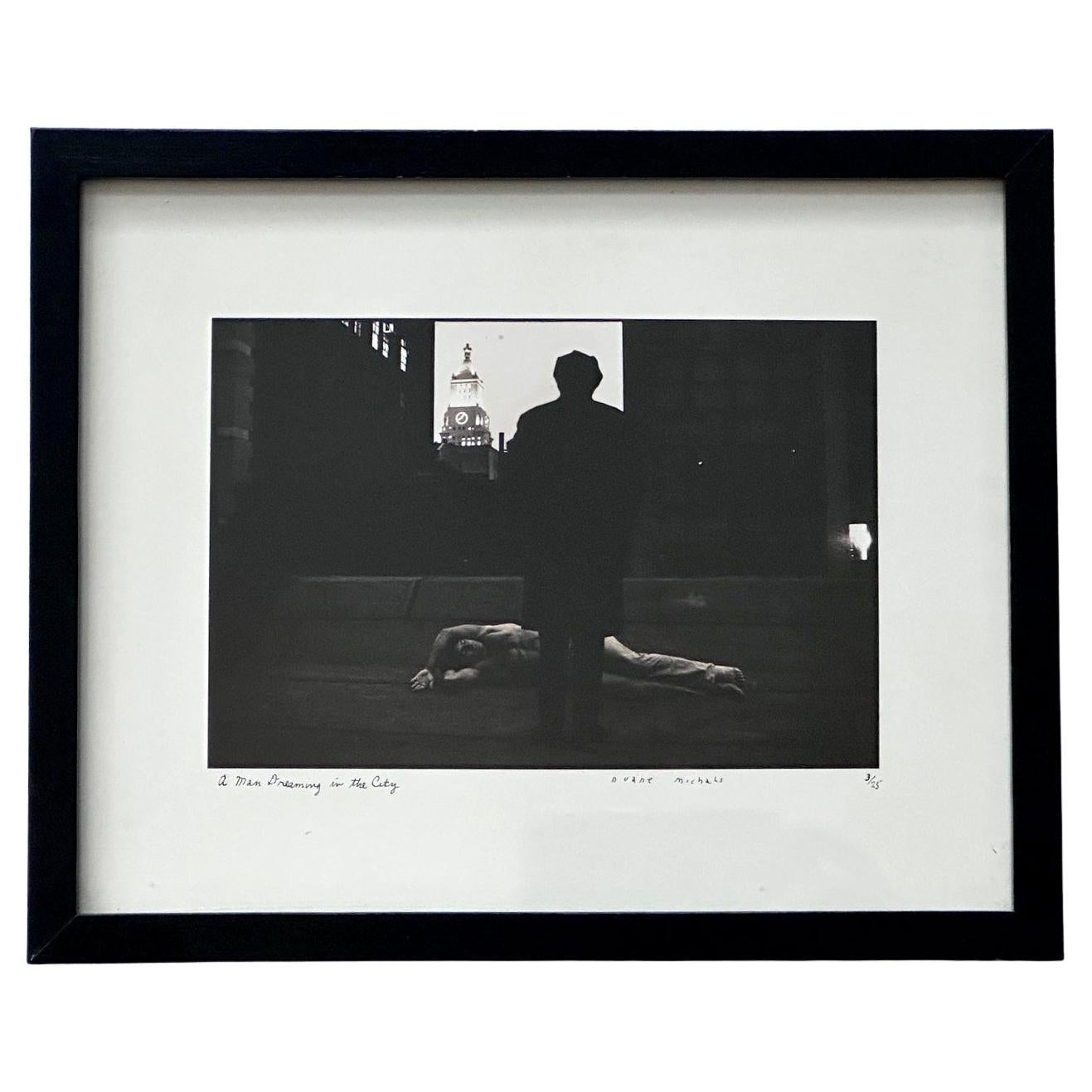 Fotografía enmarcada editada Un hombre soñando en la ciudad de Duane Michals