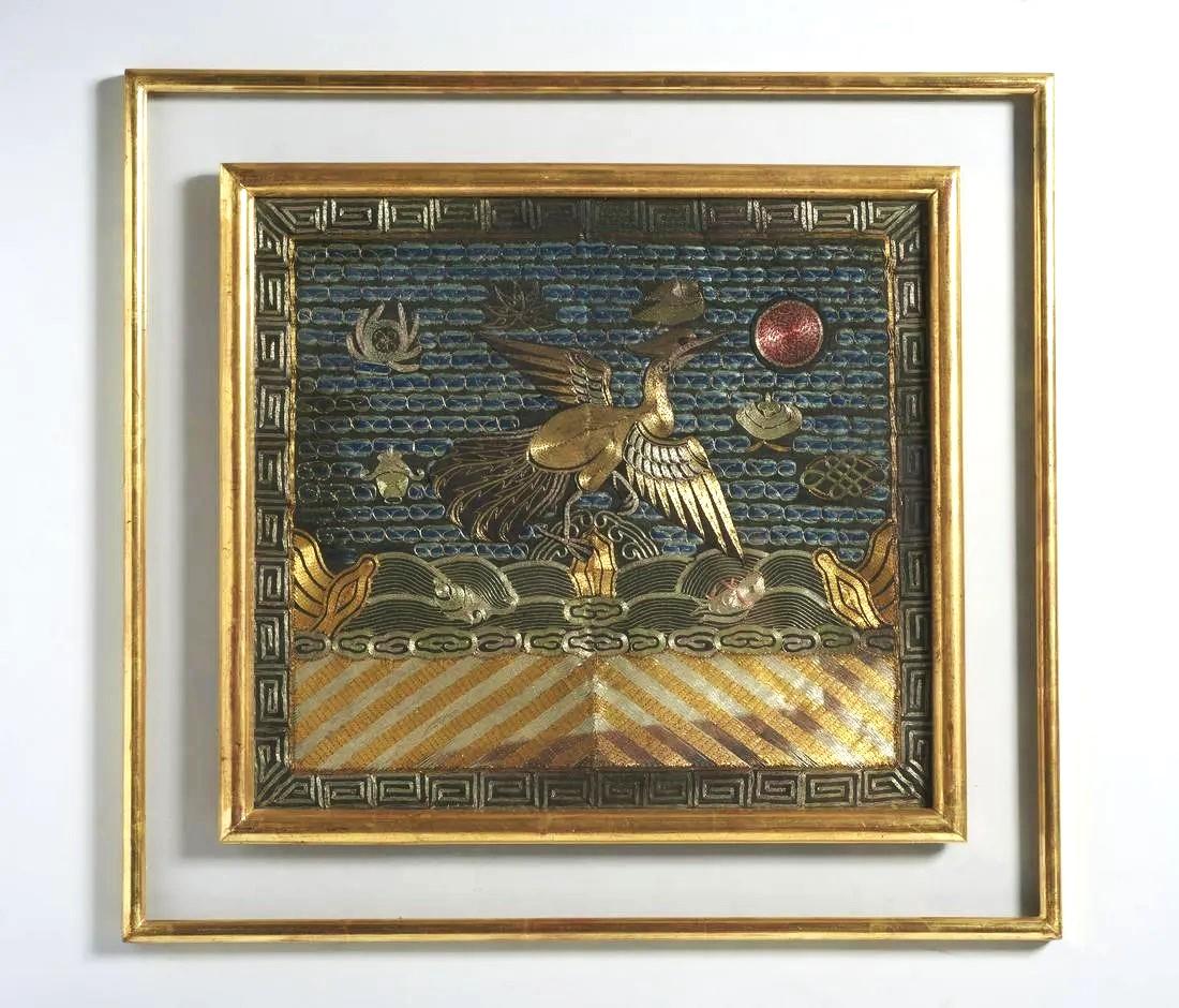 A finely embroidered silk civil rank badge panel presented in a double giltwood frame with glass surround circa mid-late 19th century Qing Dynasty. The square rank badge is known in Chinese as Buzi. The design is centered by a golden peasant, the
