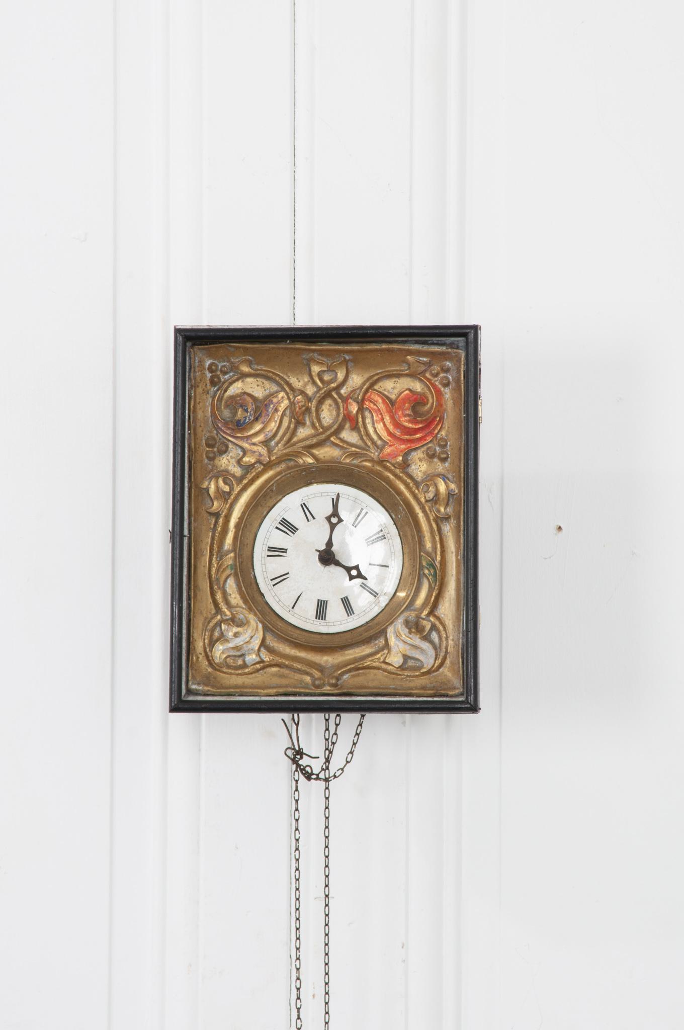 Although this German Black Forest 19th century framed clock no longer works, the beauty of its composition gives it another life as a work of art. Behind the glass, the clock face is set in a beautifully stamped and painted metal plate. Age and use