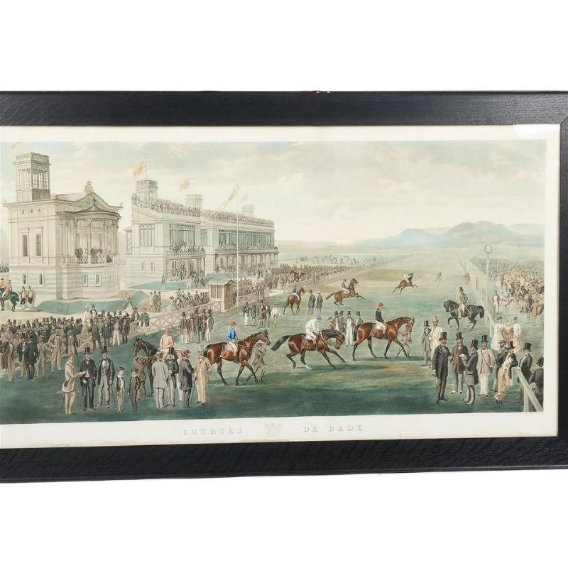 A framed French turn of the century horse race scene. The large scene depicts jockeys on horseback getting ready for a race with men and women mingling about the grounds in front of a large traditional viewing area. Framed in a black frame and