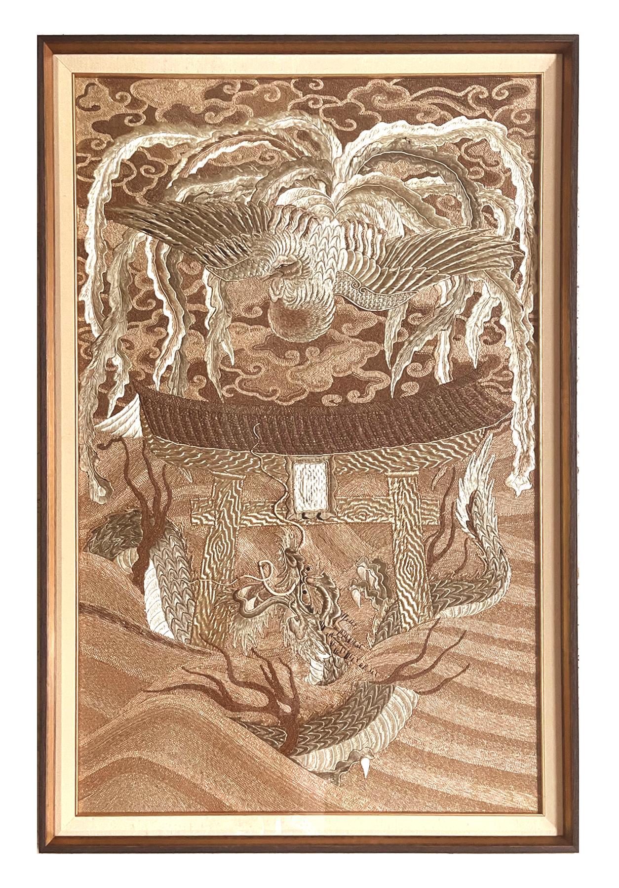 A visually stunning Japanese embroidery tapestry circa 1890s-1900s late Meiji period, presented with a linen matt with gold trim in a gilt wood frame. The design showcases a flying phoenix with splendid plumage above a torii gate rising from the